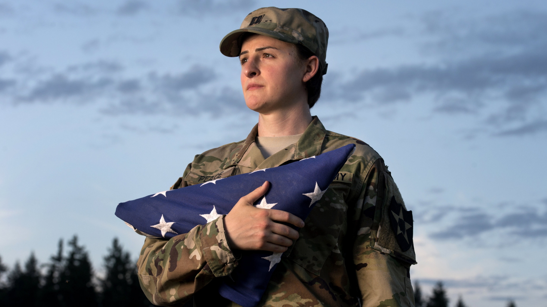 US-Soldatin Jennifer Peace hält eine US-Flagge in ihren Armen. | dpa