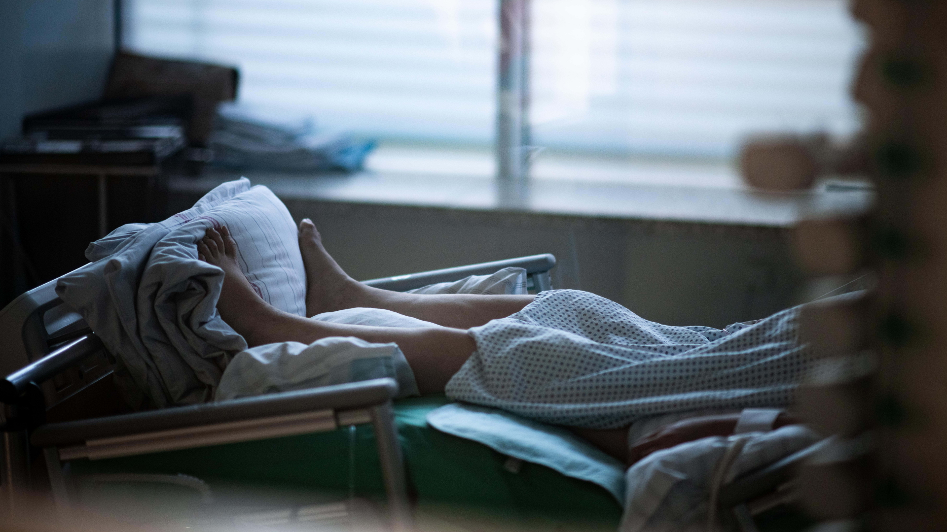Ein Patient liegt in einem Zimmer auf einer Corona-Intensivstation | dpa