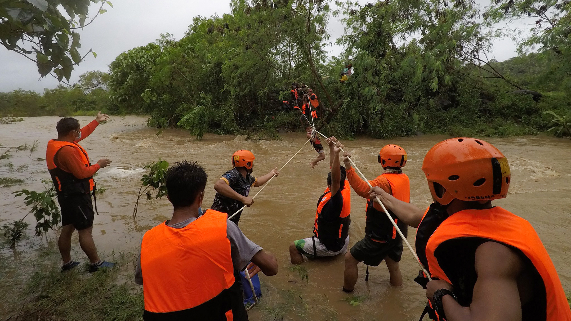 Rettungskräfte hangeln sich mit einem Seil auf das überliegende Ufer in einem überfluteten Dorf in der Stadt Gonzaga, Philippinen, 12. Oktober 2021. | EPA