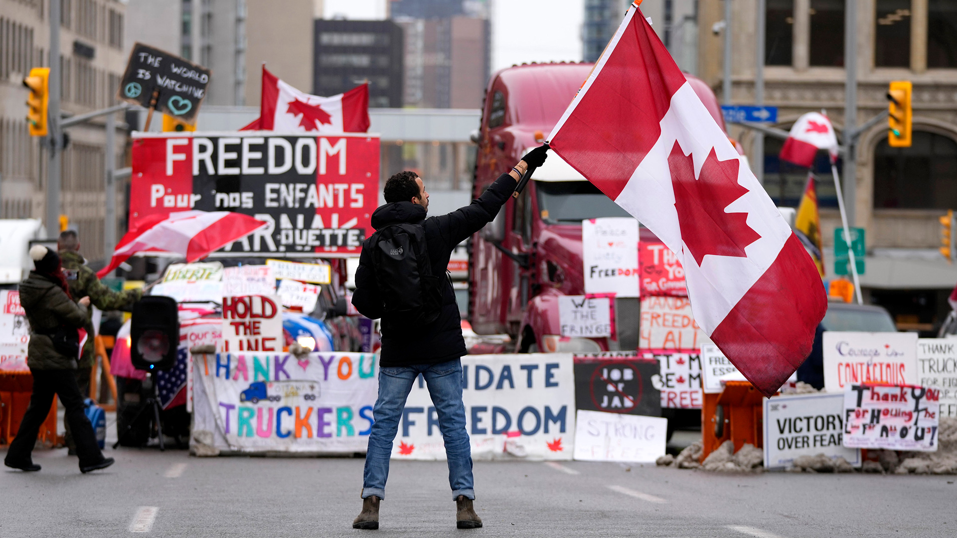 Ein Demonstrant schwenkt eine kanadische Flagge vor geparkten Fahrzeugen in der Rideau Street in Ottawa, Kanada | AP