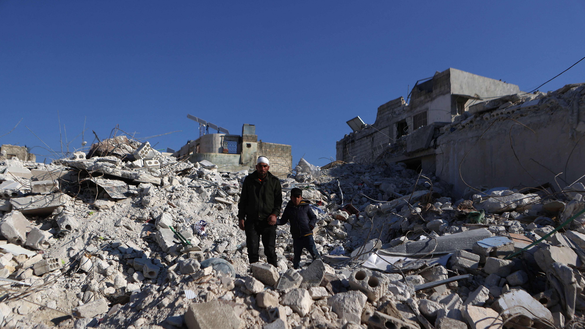 Ein Mann und ein Junge stehen in Trümmern in Aleppo | AFP