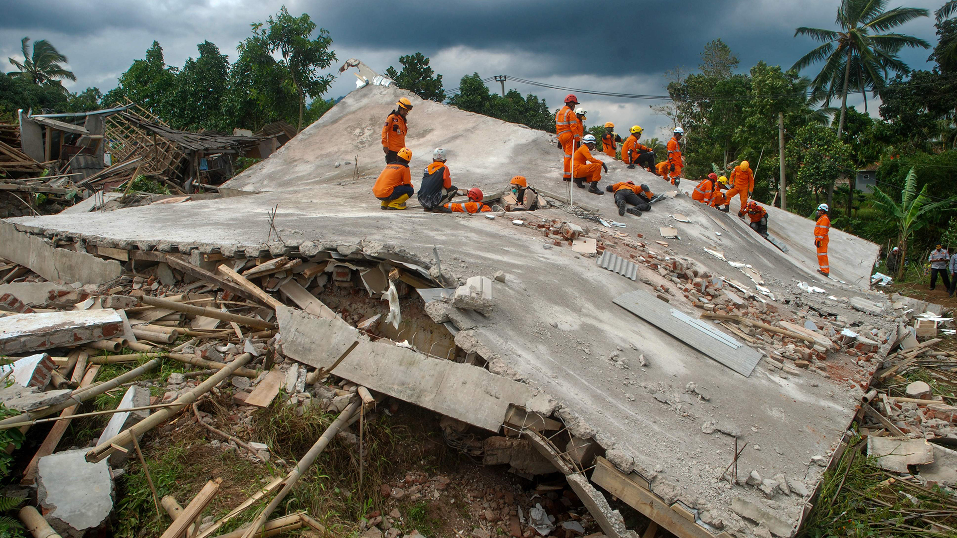 Rettungskräfte suchen unter den Trümmern eingestürzter Gebäude in Cianjur (Indonesien) nach Opfern eines Erdbebens. | AFP