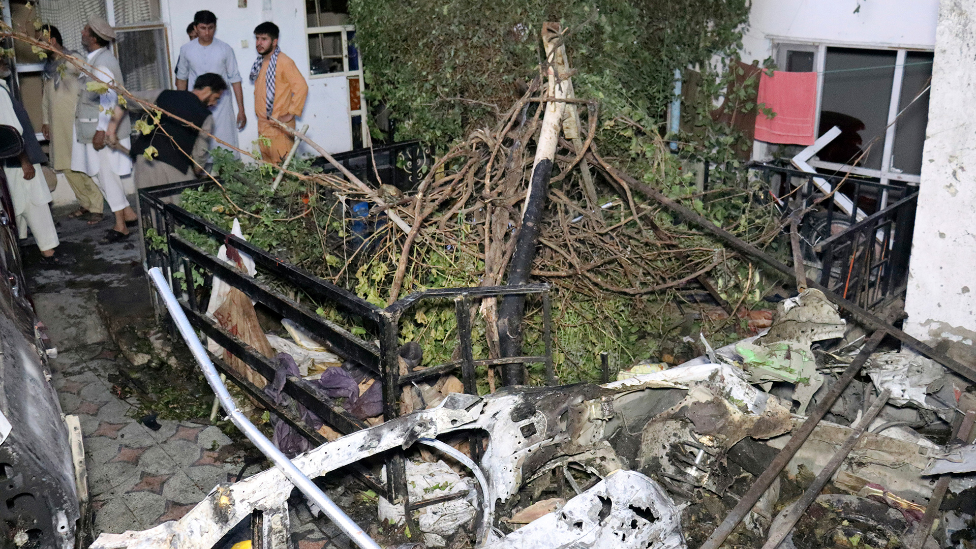 Afghanen begutachten nach einem US-Angriff-Drohnenangriff Schäden an einem Haus. | dpa