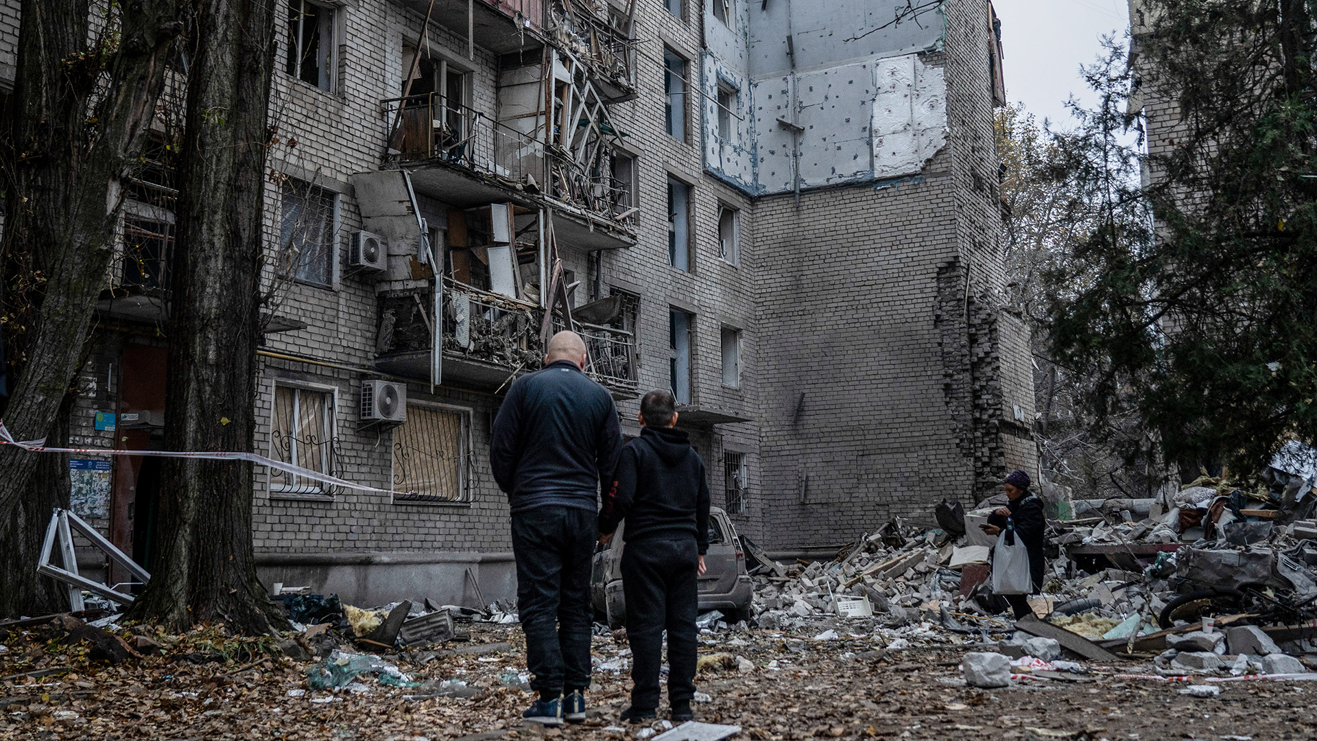 Zwei Anwohner stehen vor den Trümmern eines Gebäudes in Mykolajiw (Ukraine). | dpa