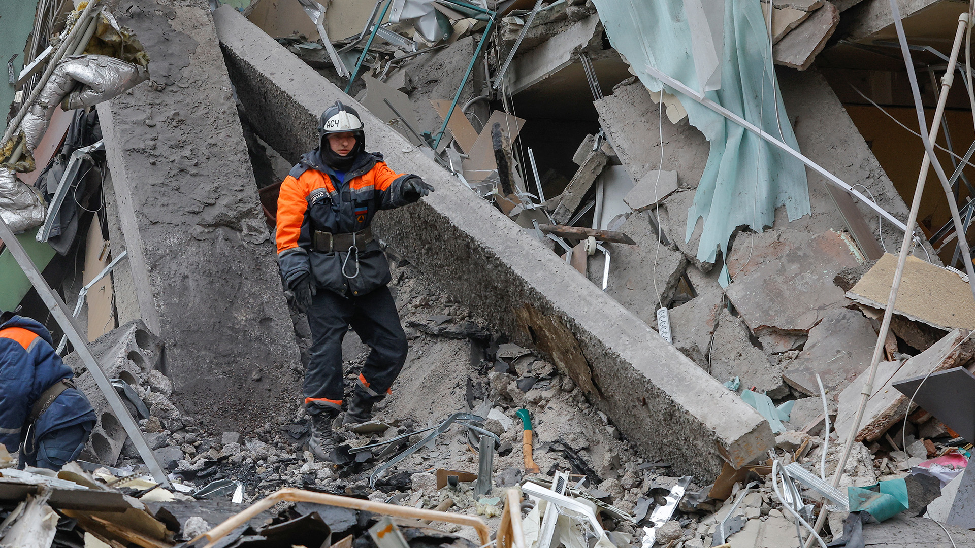 Ein Helfer geht durch die Trümmer eines Gebäudes. | REUTERS