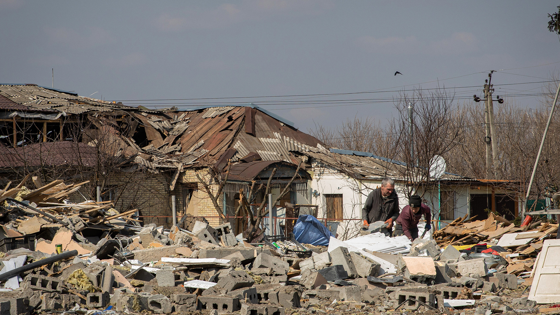 Zwei Männer räumen die Trümmer eines Beschusses in der Oblast Kiew weg, Ukraine | dpa
