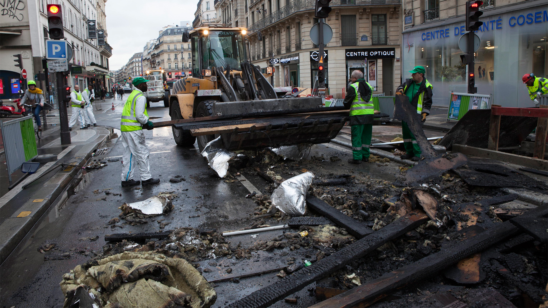 Arbeiter beseitigen die Trümmer in einer Straße in Paris | Bildquelle: dpa