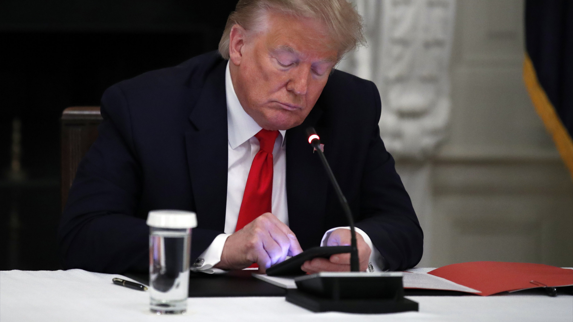 Ex-US-Präsident Donald Trump schaut auf sein Mobiltelefon (Archiv) 