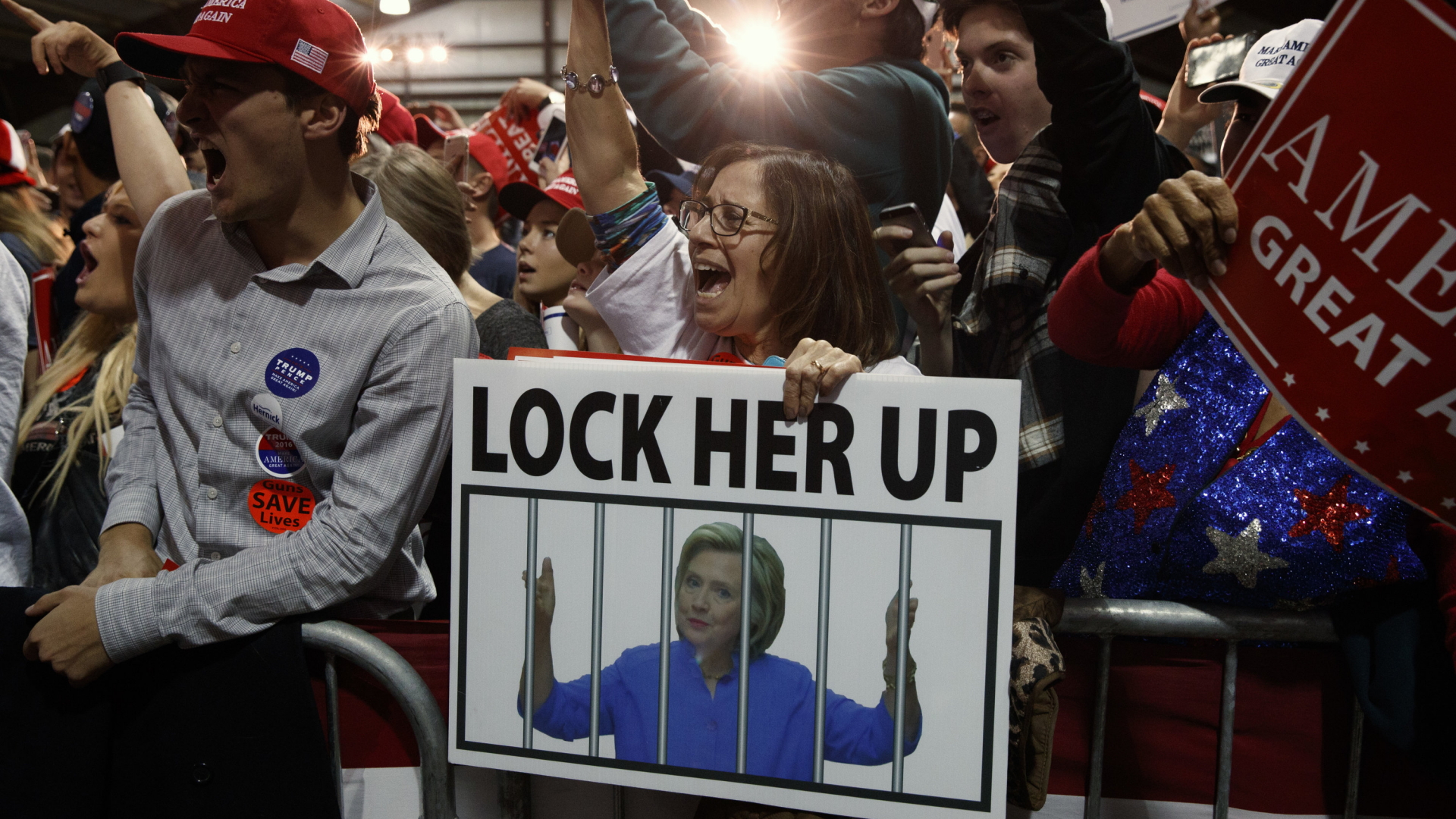 Trump-Anhänger halten Plakate hoch mit der Forderung, die demokratische Kandidatin Clinton einzusperren. | AP