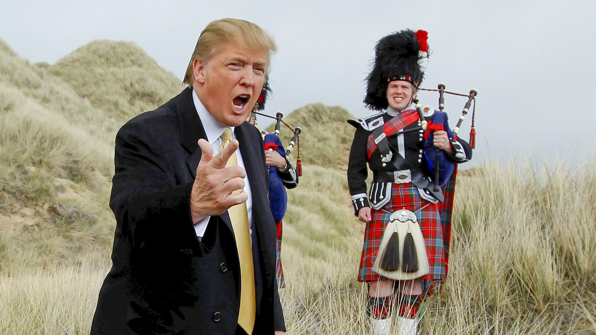 Donald Trump spricht in Schottland neben einem Mann in Schottischer Kleidung.