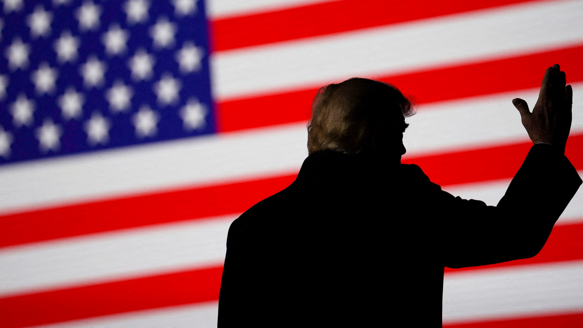 Donald Trumps Silhouette ist vor einer US-Flagge zu sehen (Archivbild).