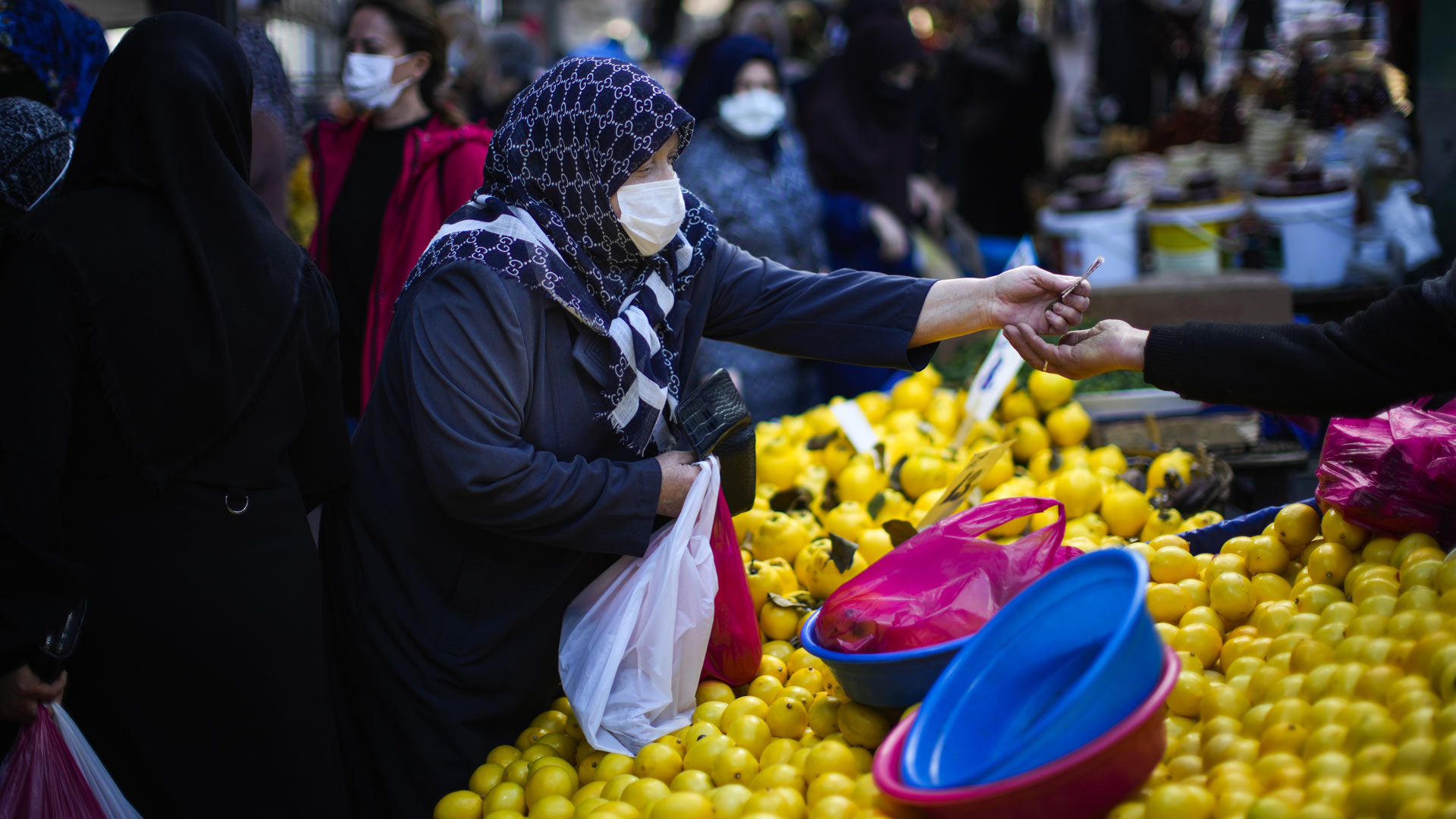 Eine Frau kauft auf einem Straßenmarkt ein. | picture alliance/dpa/AP