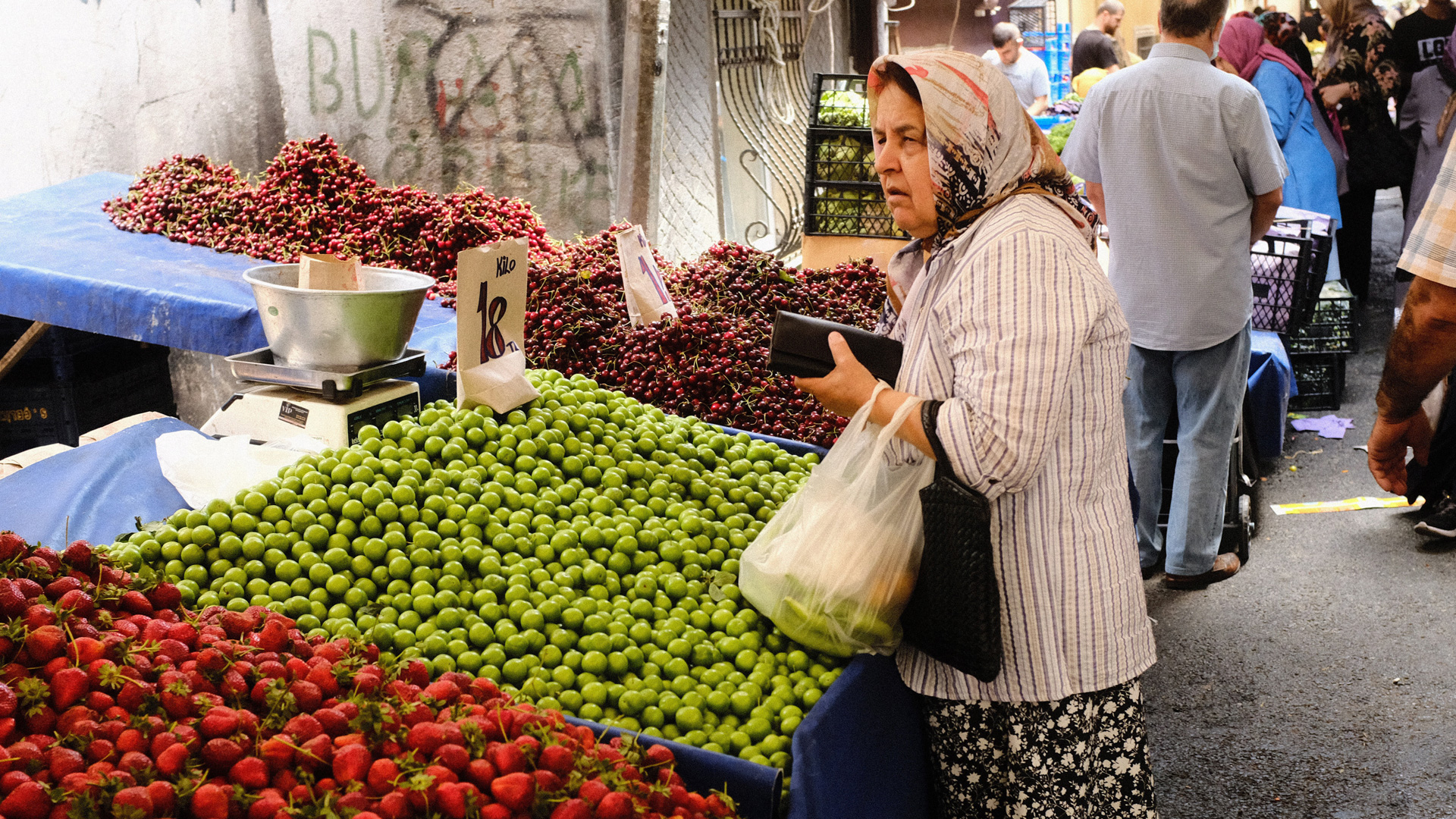 Eine Frau kauft auf einem Straßenmarkt ein. | dpa