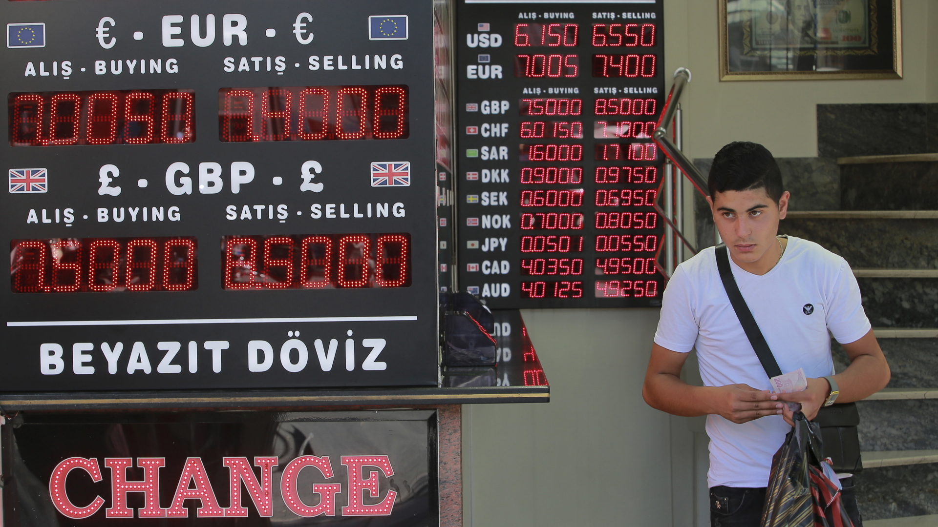 Ein Mann läuft an einer Anzeigetafel mit den Wechselkursen ausländischer Währungen vorbei. | dpa