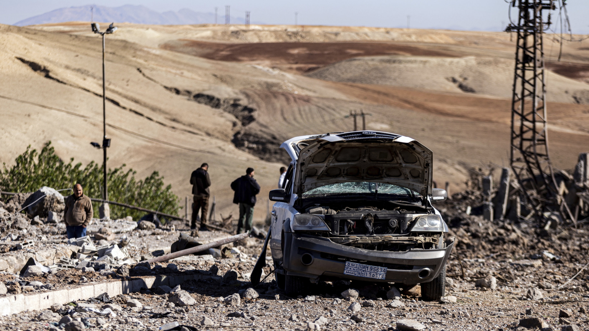 Ein zerstörtes Auto steht nach einem türkischen Luftangriff auf einer zerstörten Straße in Syrien
