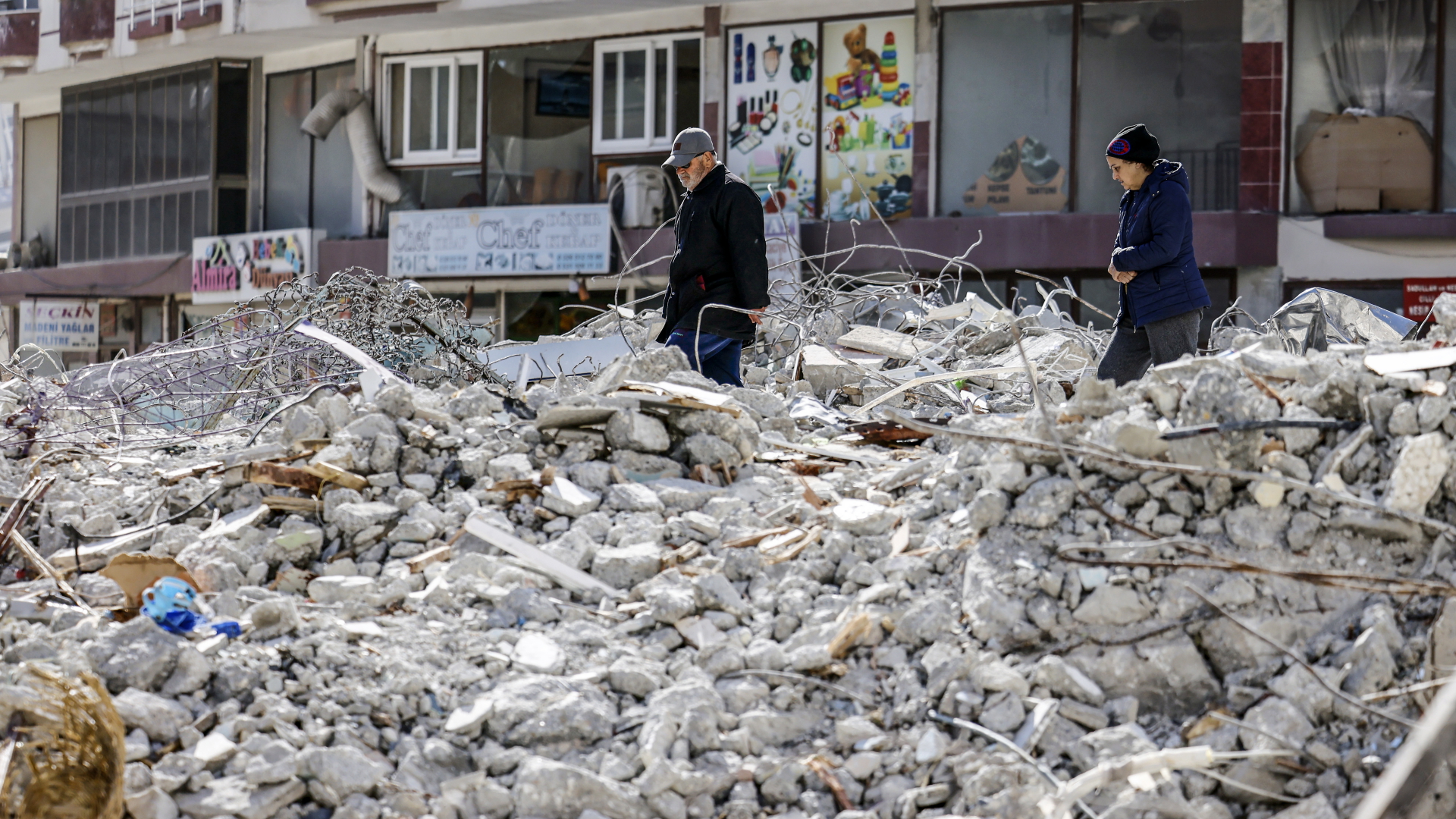 Menschen gehen nach der Erdbebenkatastrophe durch die Trümmer in der türkischen Stadt Samandag.