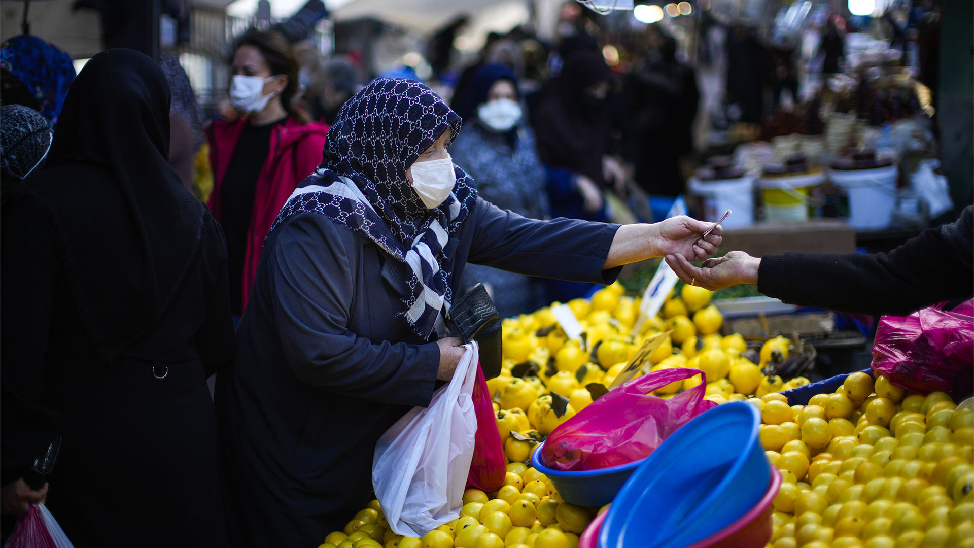 Eine Frau zahlt mit Türkischen Lira an einem Marktstand | picture alliance/dpa/AP