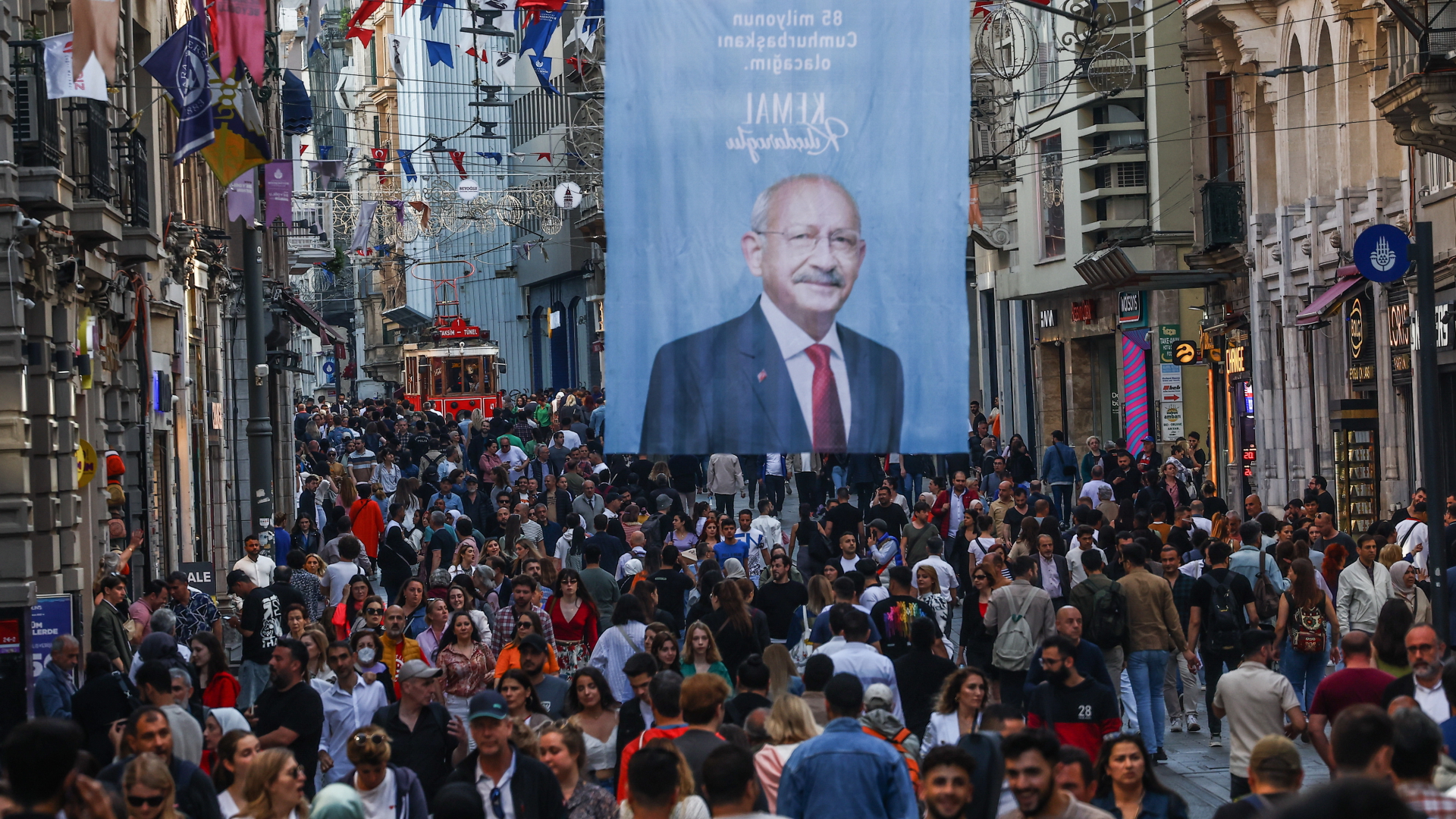In Istanbul hängt über einer von Passanten gesäumten Straße ein Wahlplakat des Präsidentschaftskandidaten Kilicdaroglu.