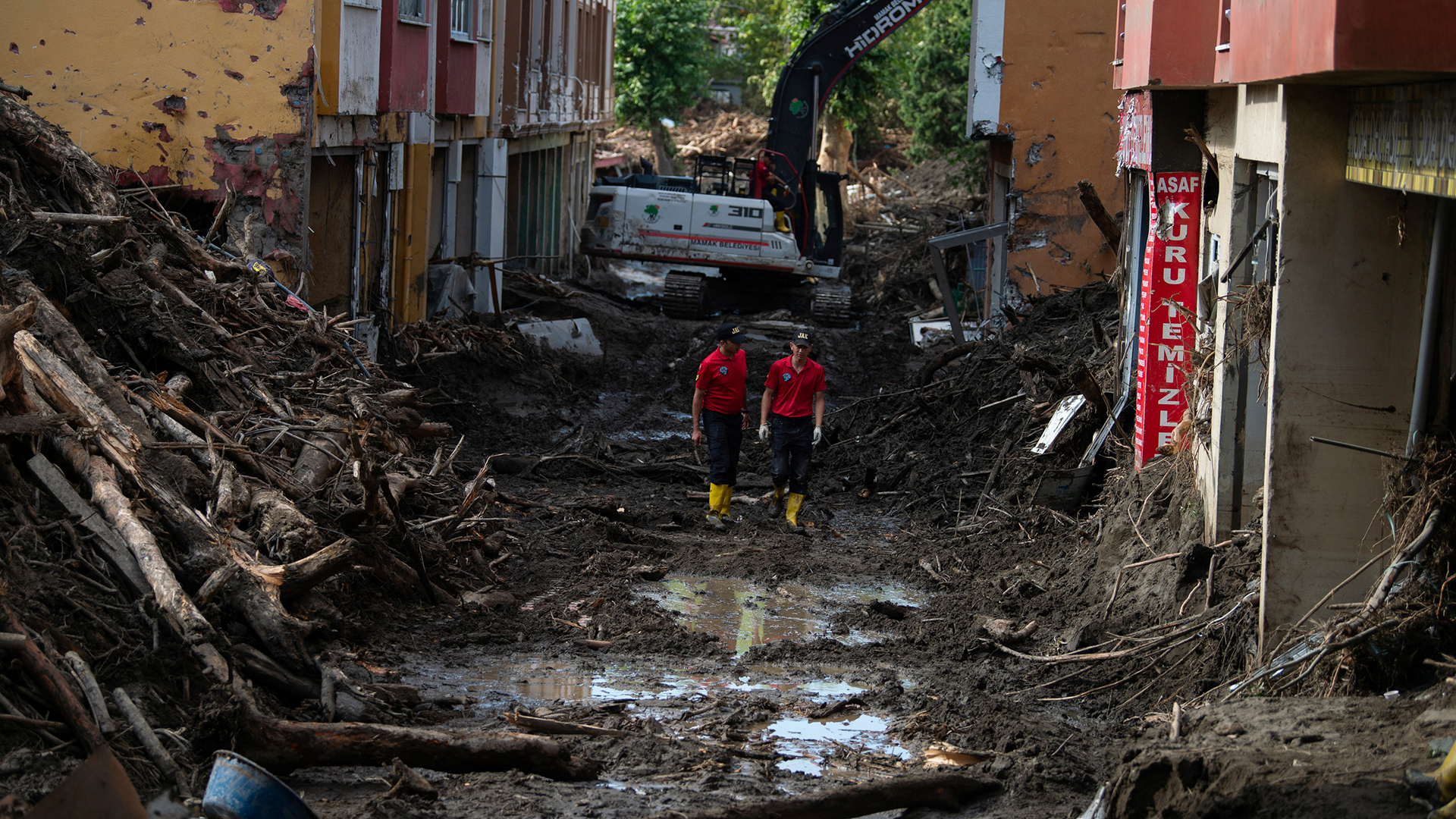 Rettungskräfte gehen in der Stadt Bozkurt in der türkischen Provinz Kastamonu nach einer Überschwemmung durch eine Straße. 
