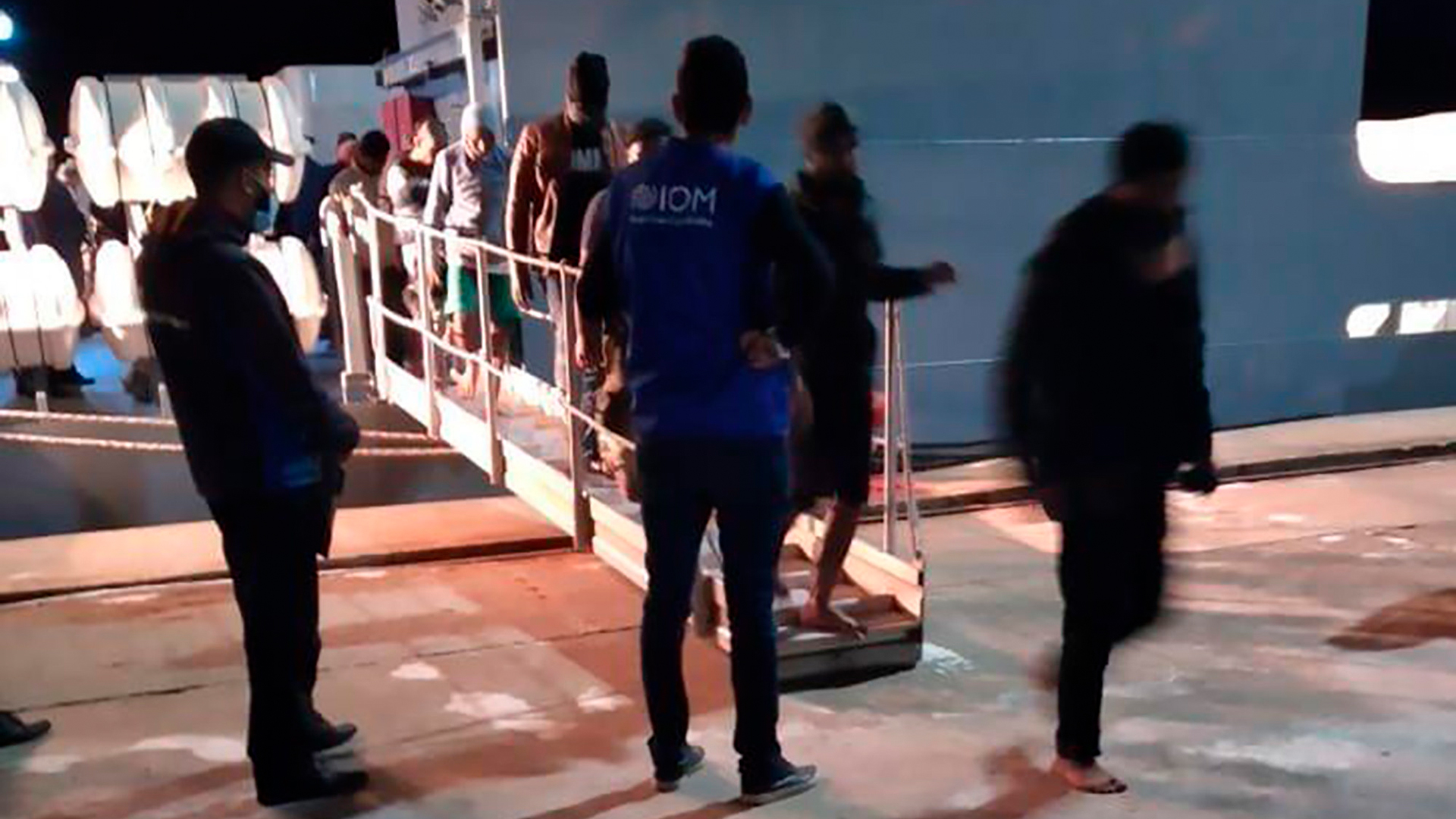 Migranten verlassen ein Schiff in einem Hafen in Tunesien. | AP