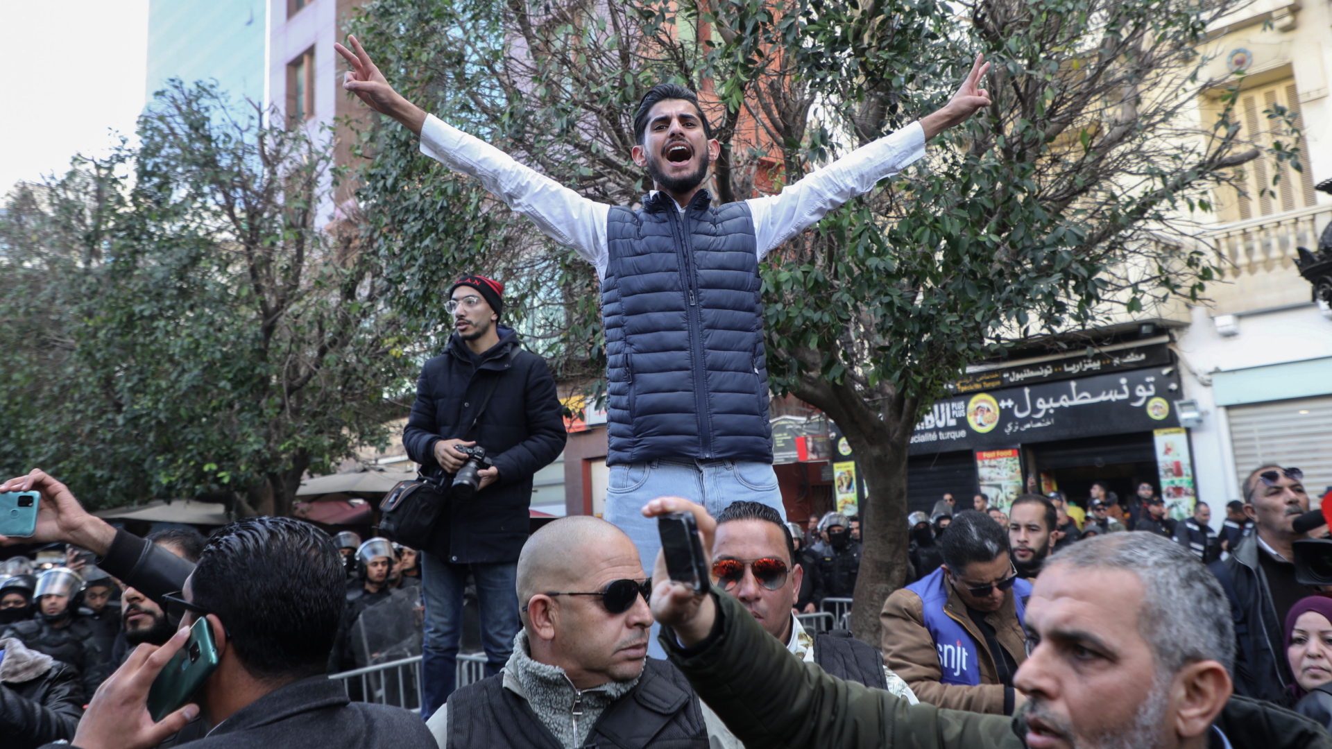 Ein Mann zeigt während einer Demonstration gegen den Präsidenten das Victory-Zeichen (Januar 2023). | dpa