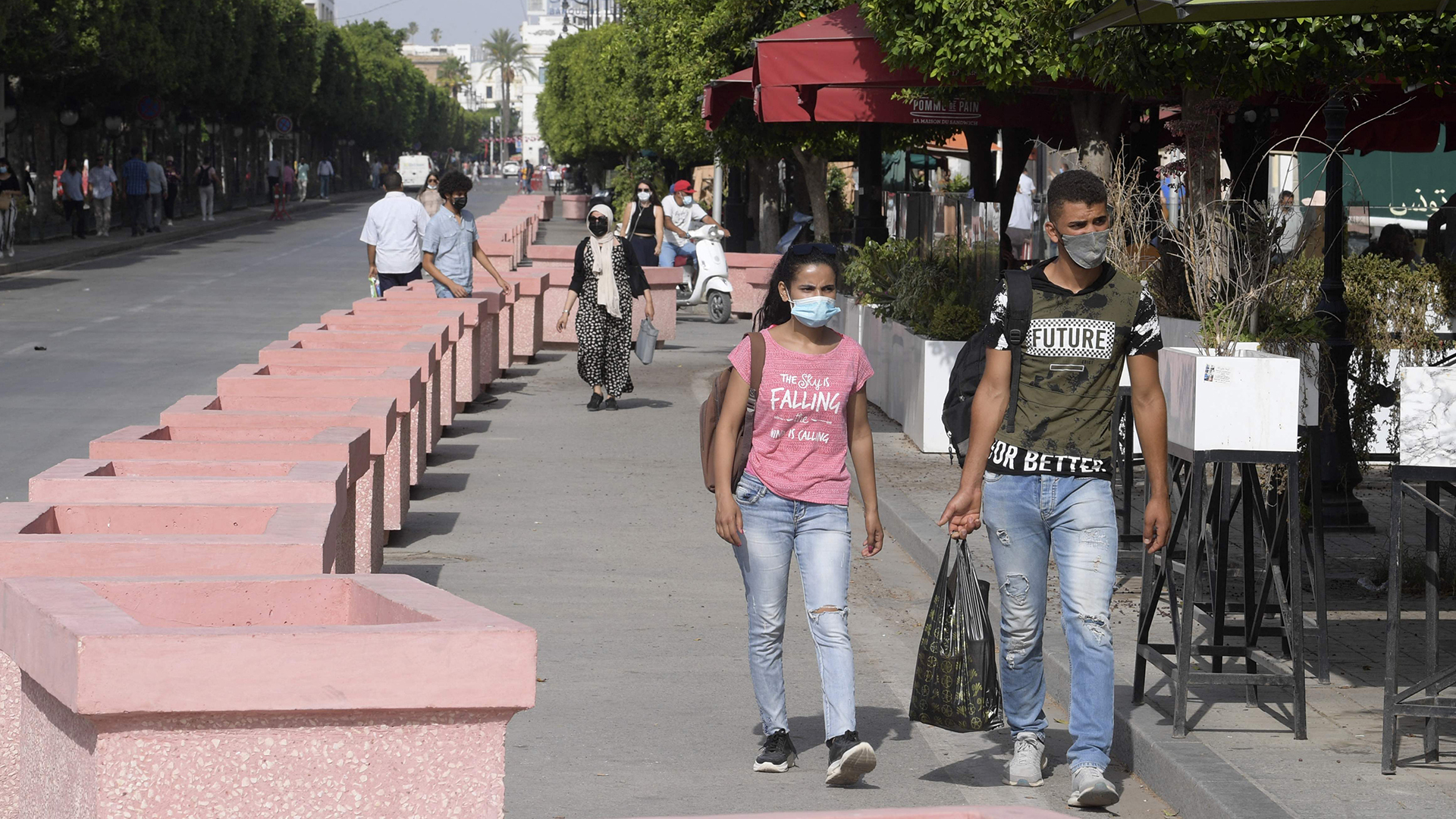 Tunesier gehen in der Habib-Bourguiba-Allee in Tunis entlang. | AFP