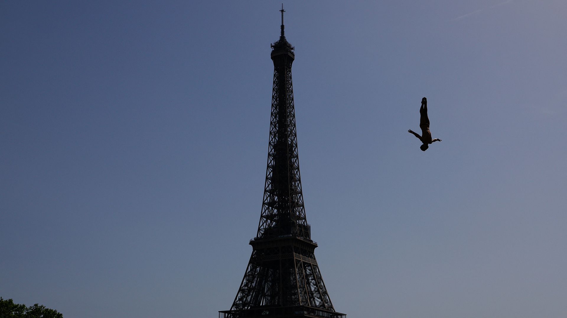 Ein Turmspringer "fällt" neben dem Eiffelturm ins Wasser. | REUTERS