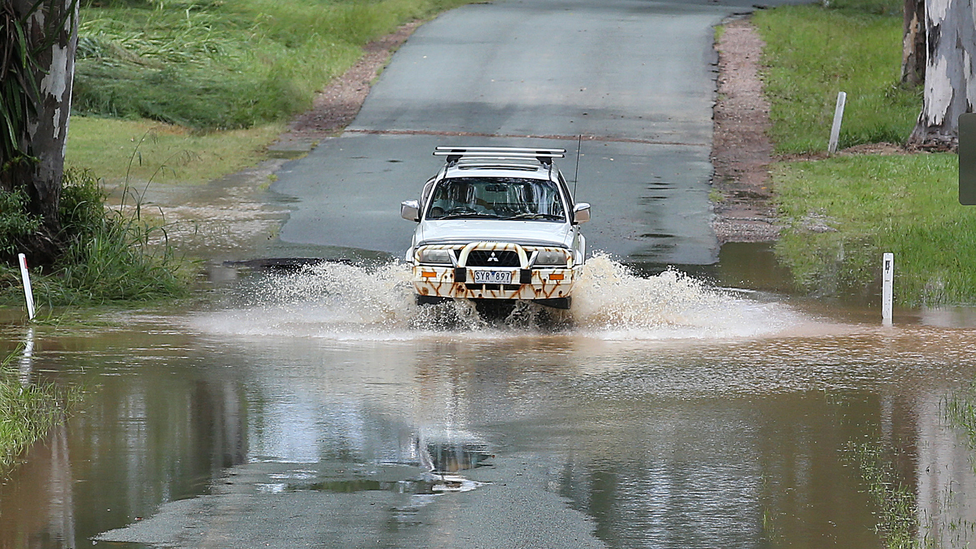  Ein Auto fährt im Hochwasser einer überschwemmten Straße in der Nähe des Belli Creek (Australien). | dpa