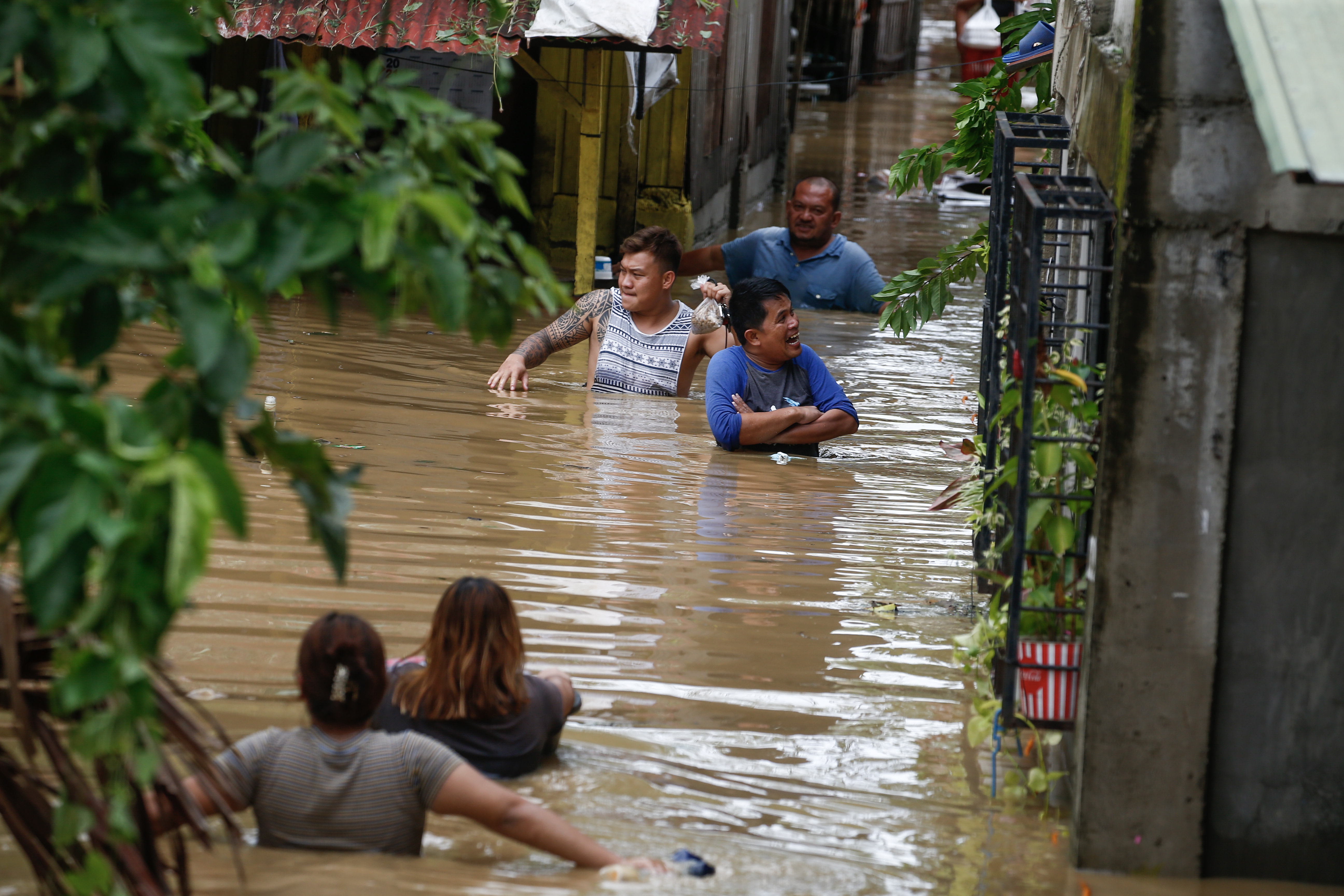 Bewohner waten durch Hochwasser in der Stadt San Miguel, nördlich von Manila.  | EPA