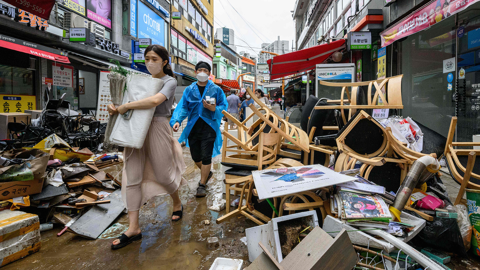 Passanten gehen an Trümmern vor den Geschäften des historischen Namseong-Marktes im Gangnam-Bezirk von Seoul (Südkorea) vorbei. | AFP