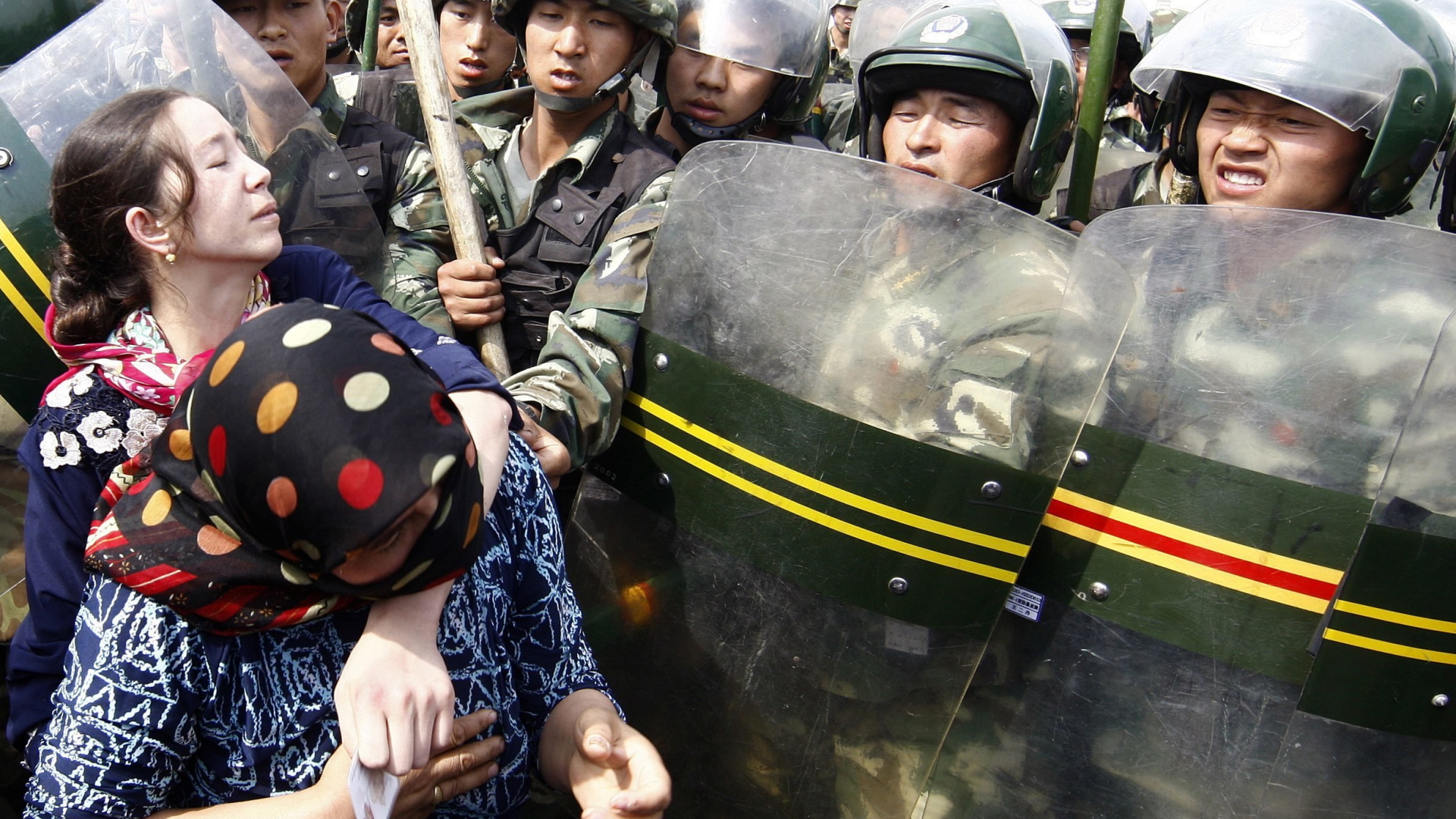 Uigurische Demonstranten wehren sich gegen einen Polizeieinsatz. 