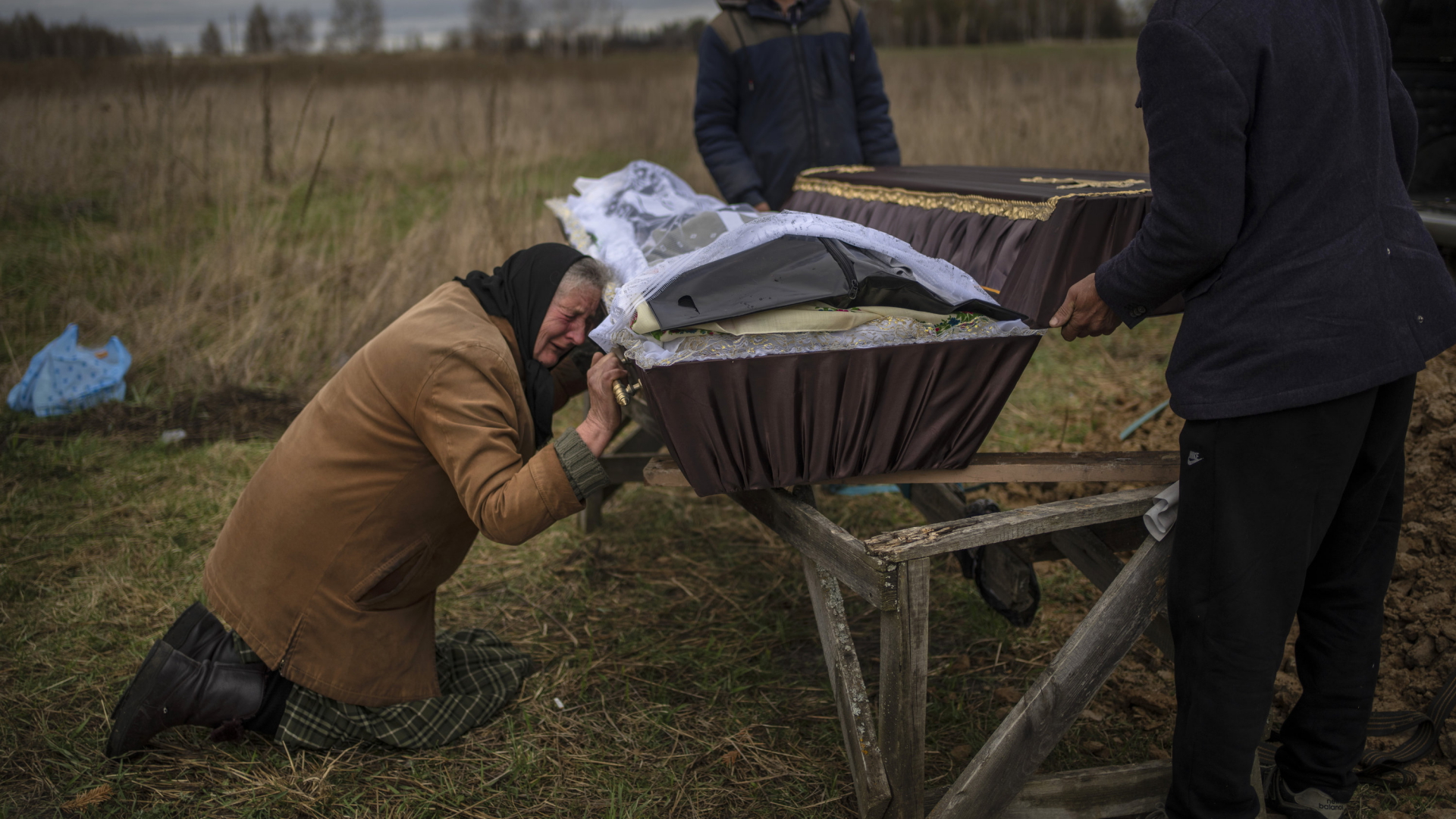 Eine Frau weint am Sarg ihres Sohnes, der von russischen Soldaten getötet wurde