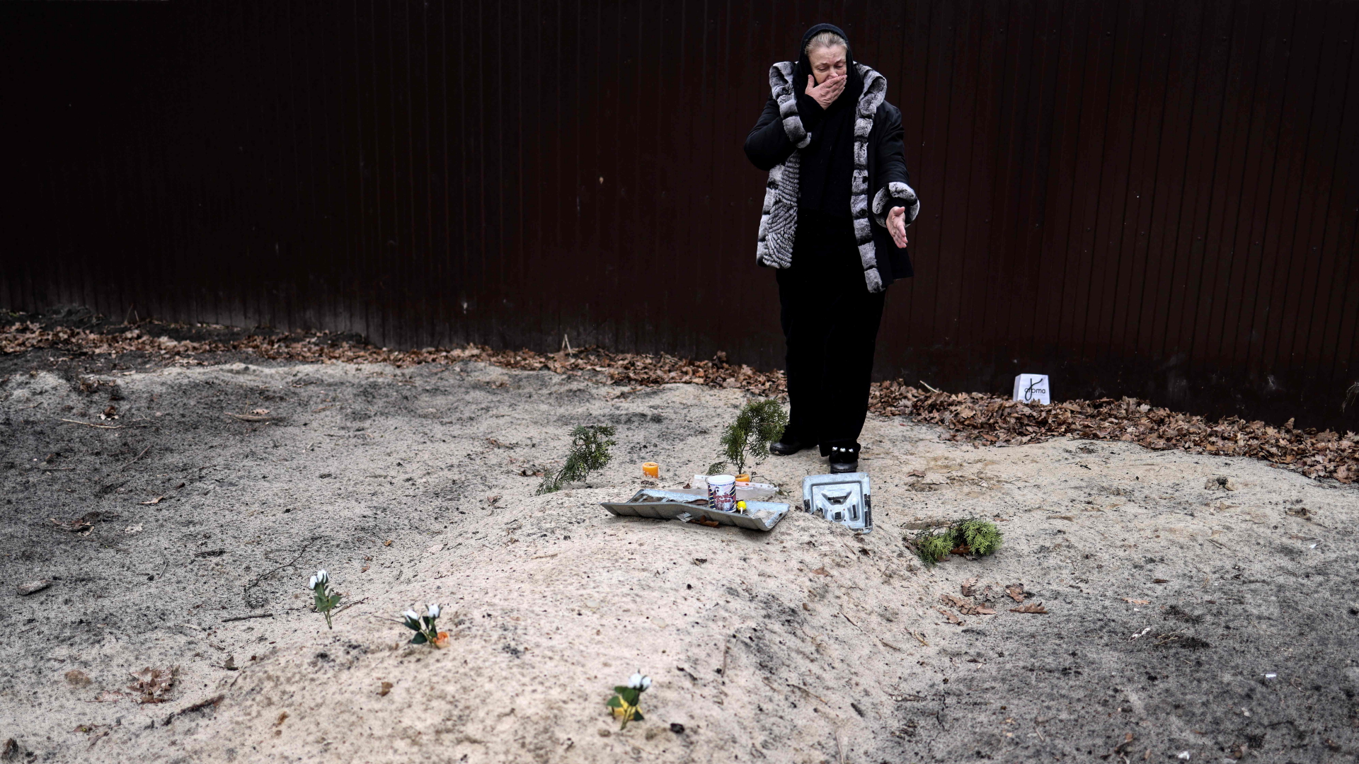 Tetiana Ustymenko weint am Grab ihres Sohnes, der im Garten ihres Hauses in Butscha, nordwestlich von Kiew, begraben liegt. | AFP
