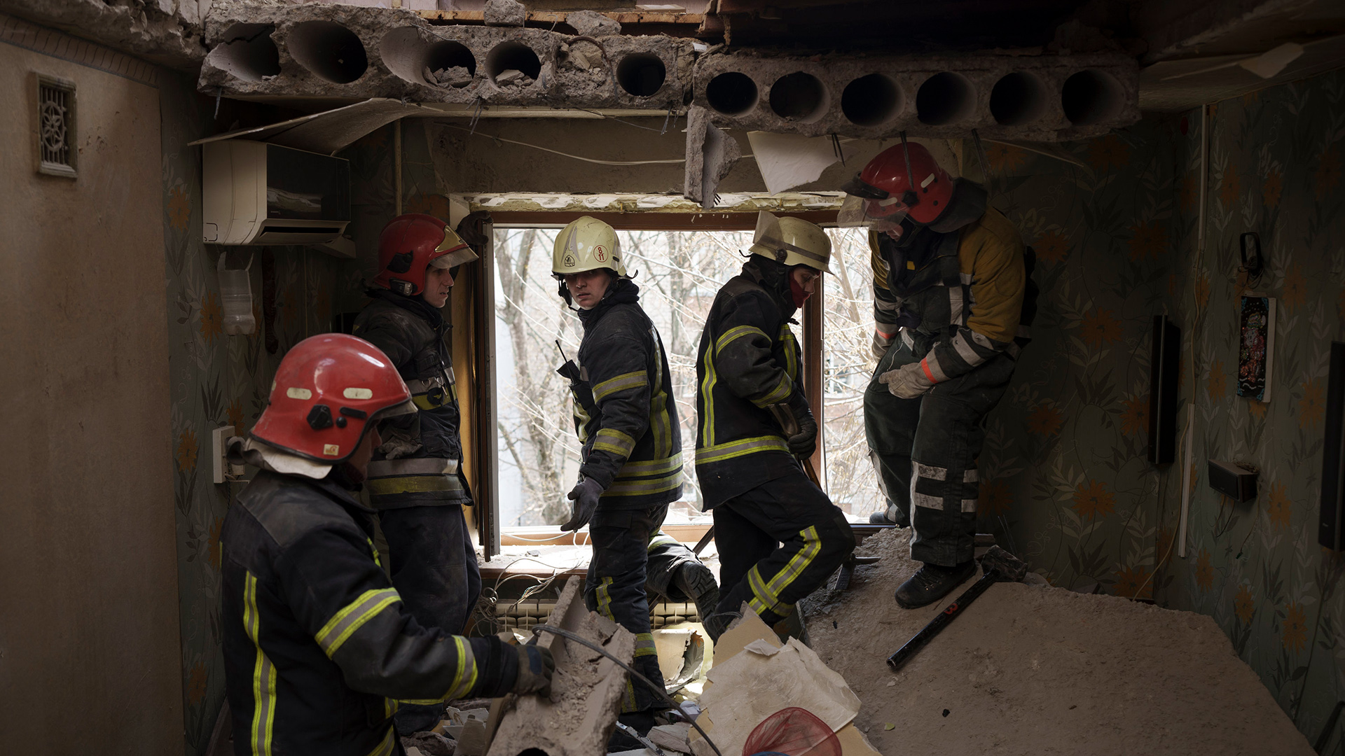 Feuerwehrleute sichern ein Wohnhaus, das zuvor durch einen russischen Angriff in Charkiw, Ukraine, beschädigt wurde. | AP
