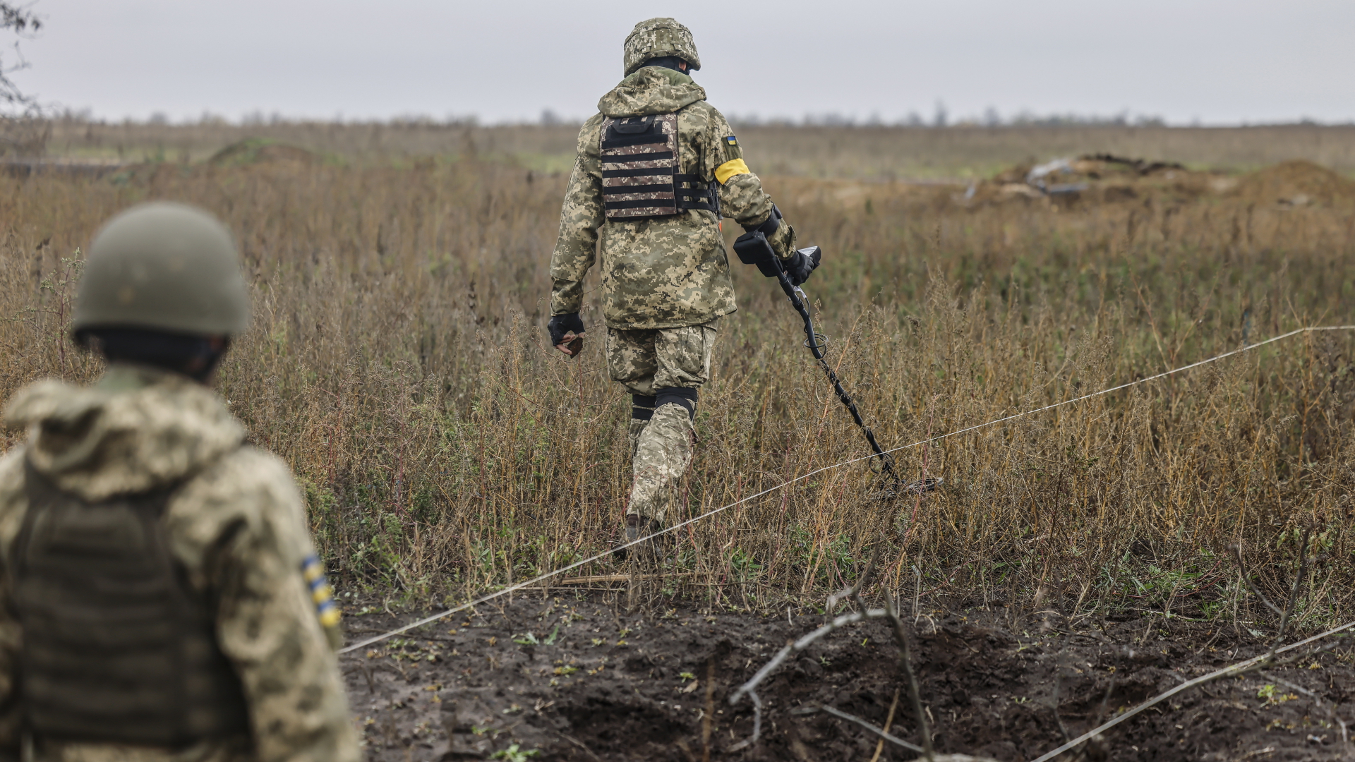 Ukrainische Soldaten suchen in der Region Cherson eine Wiese nach möglichen vergrabenen Sprengsätzen ab. | EPA