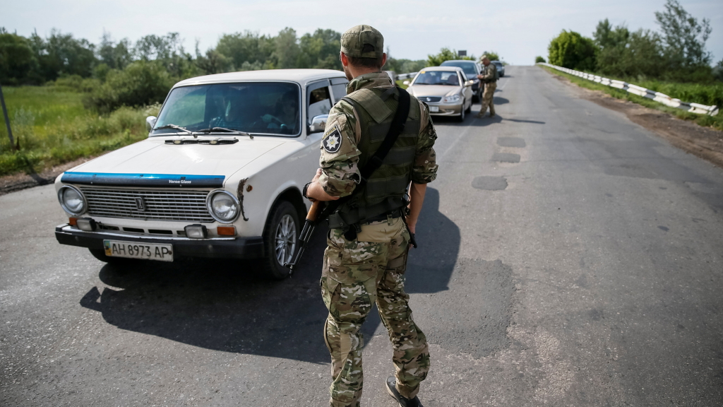 Ukrainische Sicherheitskräfte kontrollieren Fahrzeuge an einem Kontrollpunkt in der Nähe von Slawiansk (Juni 2016)