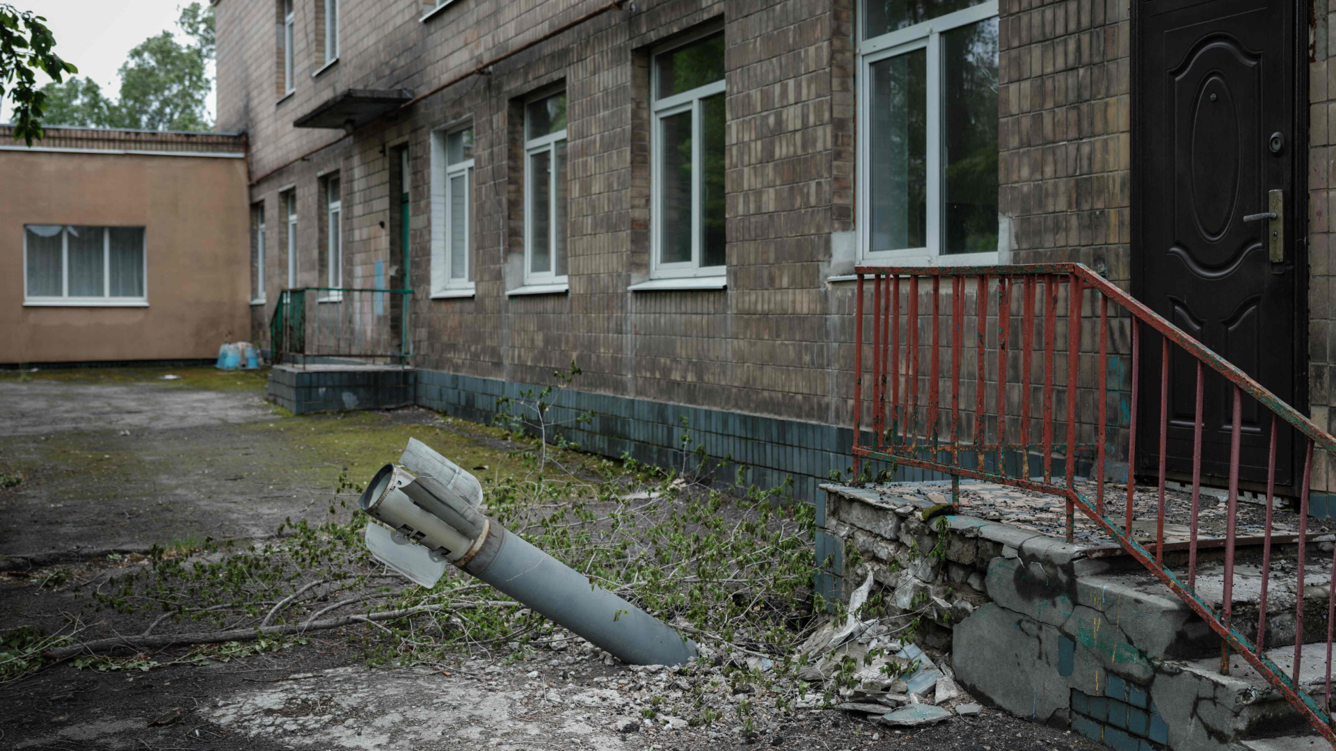 Ein nicht explodiertes Geschütz steckt im Boden vor einem verlassenen Gebäude in Lyssytschansk. | AFP