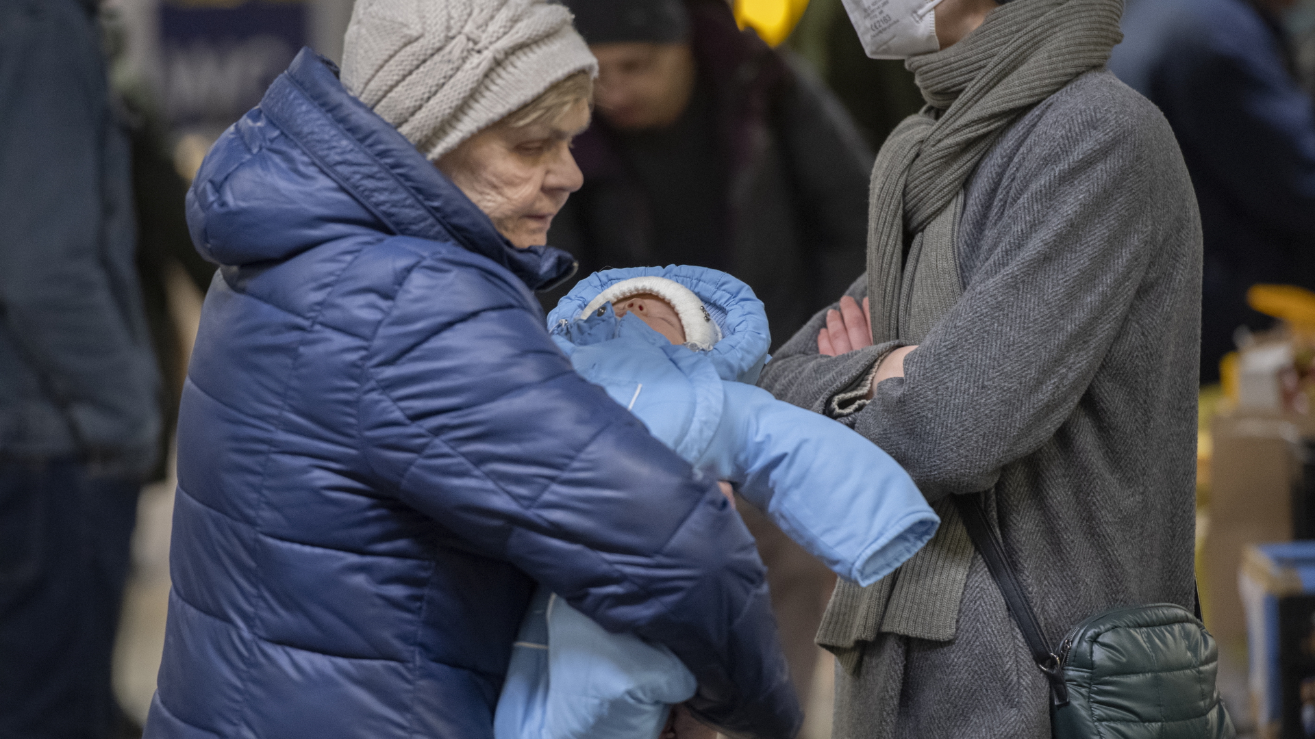 Eine ältere Frau aus dem ukrainischen Kriegsgebiet trägt im Berliner Hauptbahnhof ein Baby auf dem Arm. | dpa