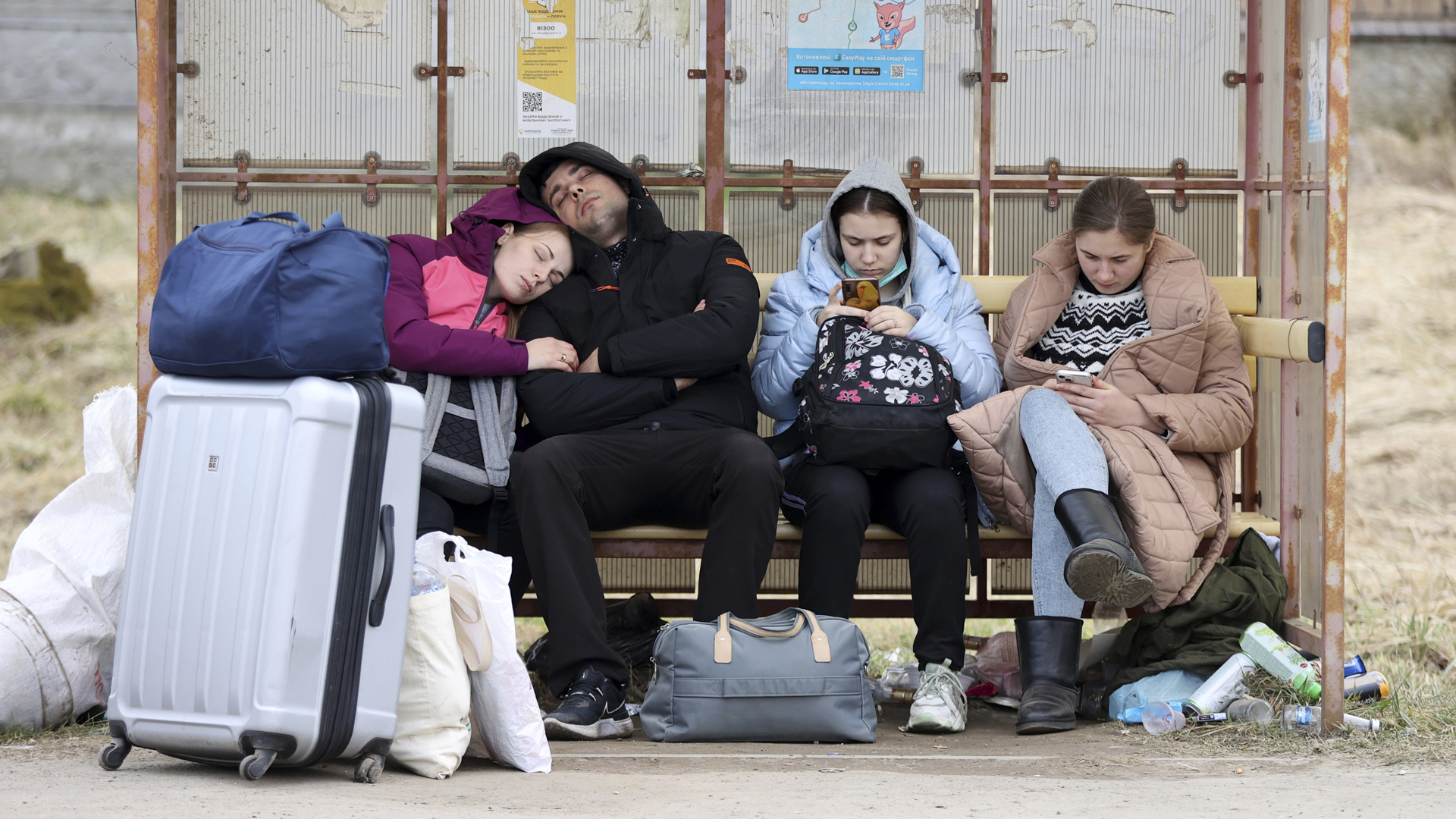 Eine Gruppe von Flüchtenden, die unterwegs zur polnischen Grenze ist, legt in der Oblast von Lwiw eine Ruhepause ein. | picture alliance / ASSOCIATED PR