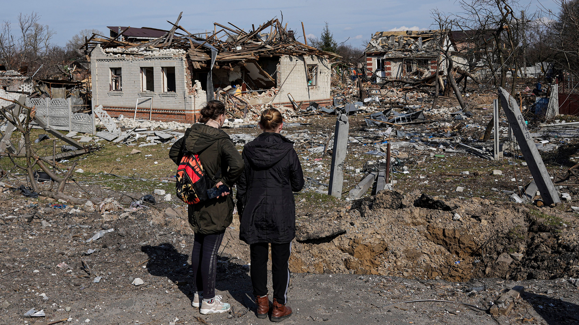 Zwei Frauen schauen auf zerstörte Häuser Tschernihiw (Ukraine). | AP