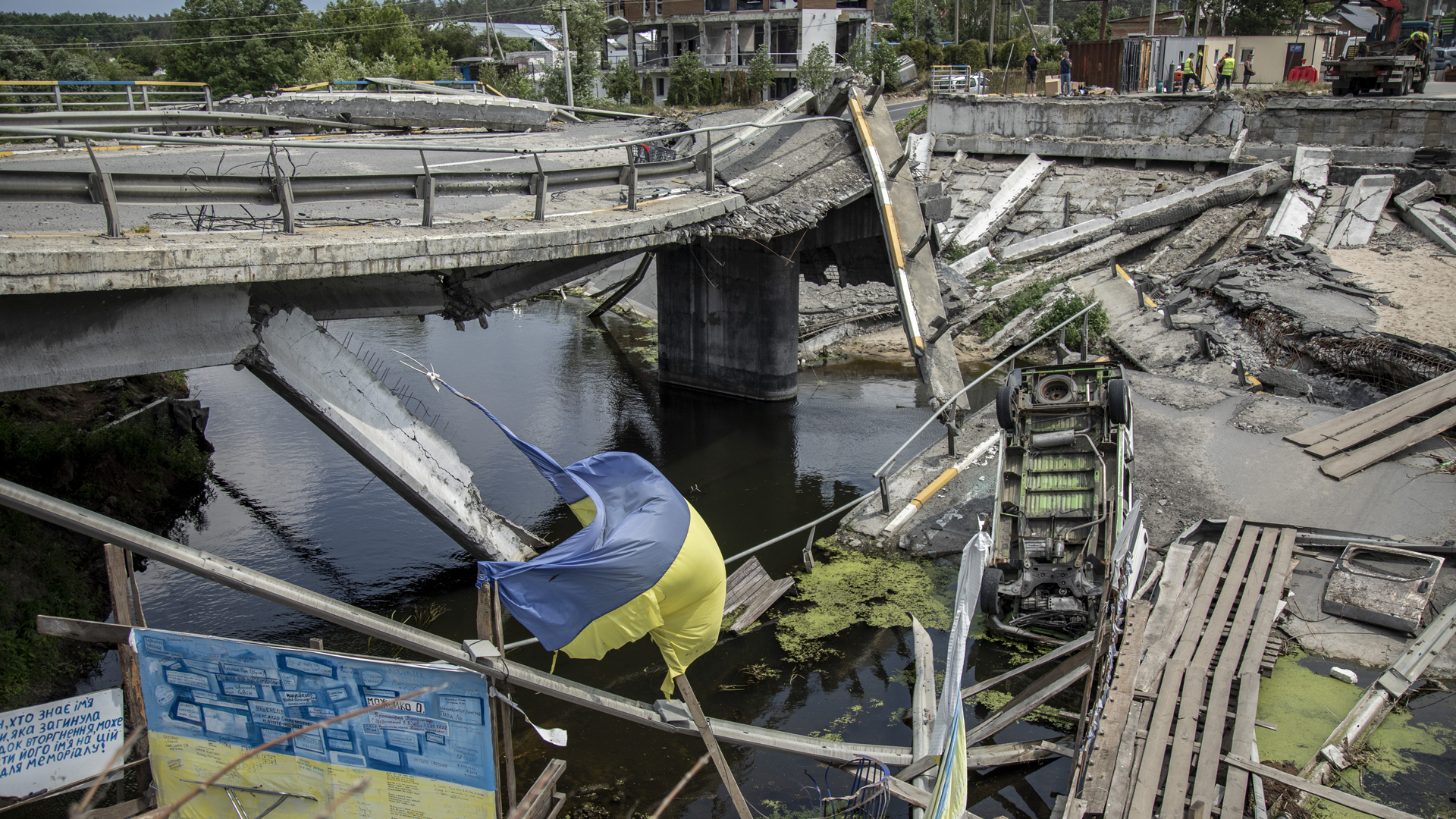 Die ukranische Flagge vor einer zerstörten Brücke im Kiewer Vorort Iripin. | picture alliance / AA