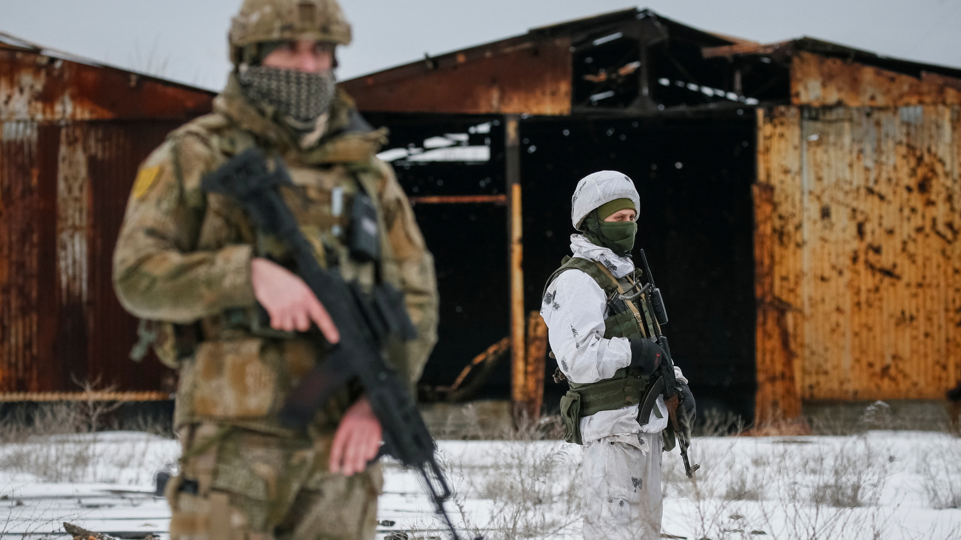 Zwei Soldaten stehen mit Gewehren vor einer verrosteten Hütte | REUTERS