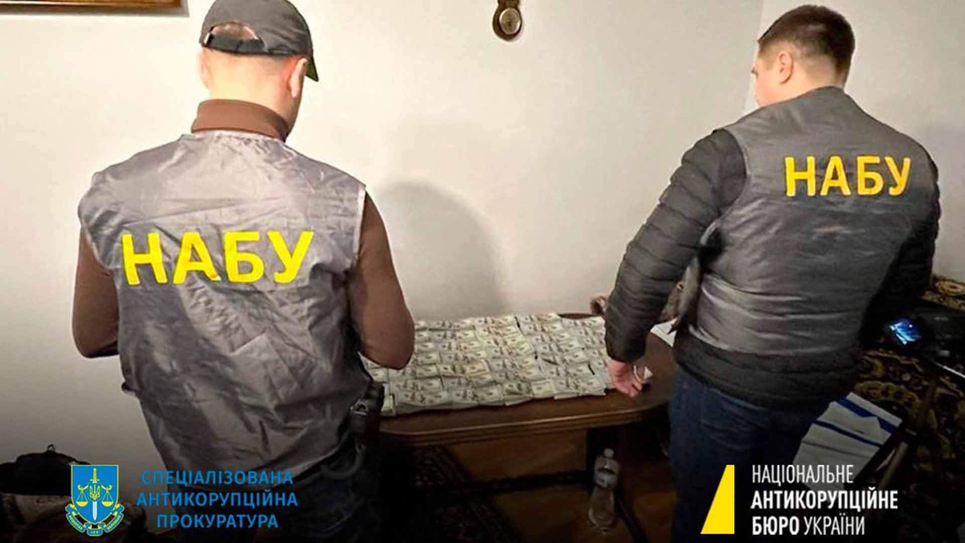 Ein Bild der Anti-Korruptionsbehörde der Ukraine zeigt einen Einsatz, bei dem Beamte Geld beschlagnahmen. | AFP