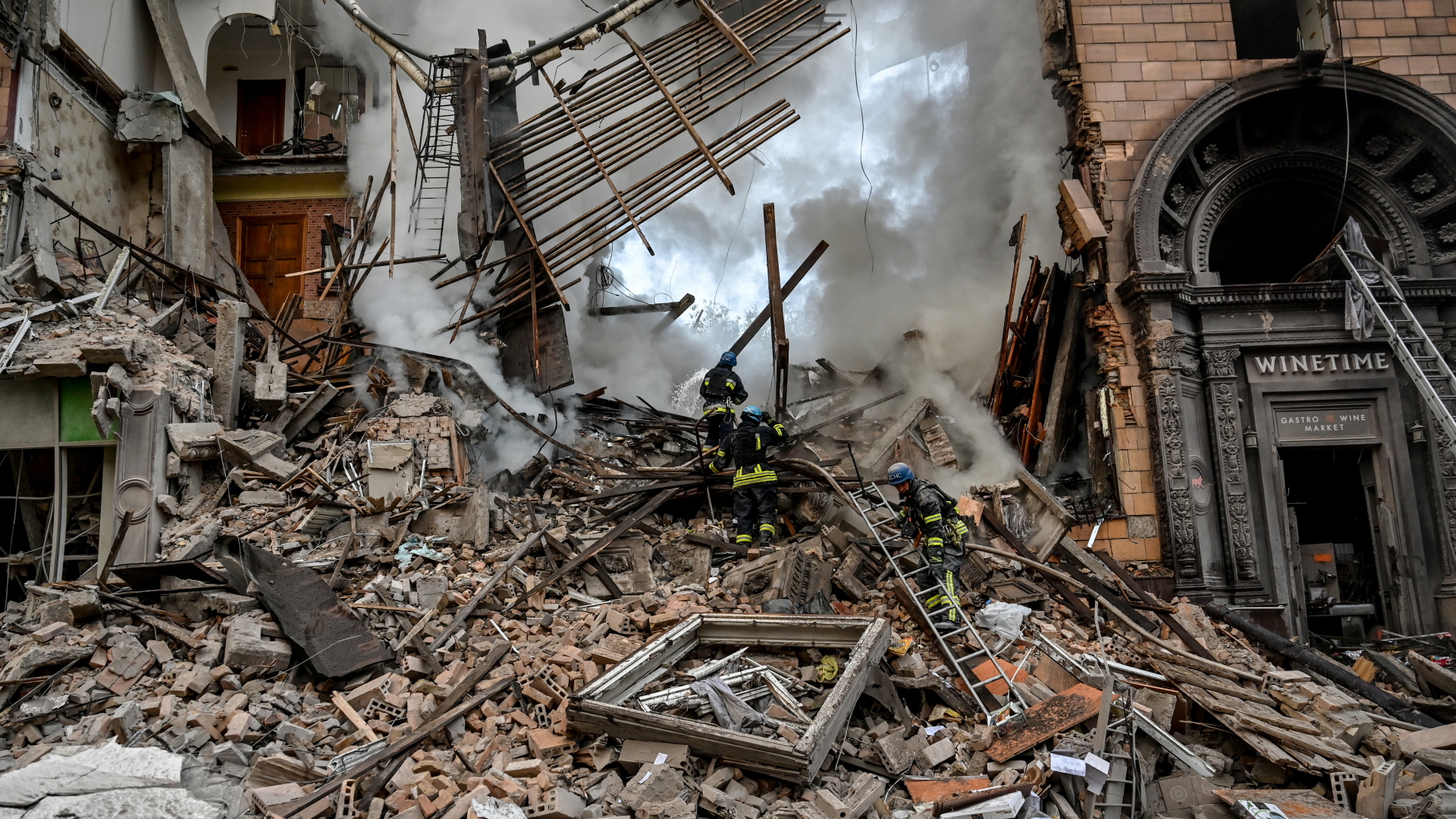 Rettungskräfte arbeiten am Einsatzort eines durch Beschuss beschädigten Gebäudes in Saporischschja. | dpa