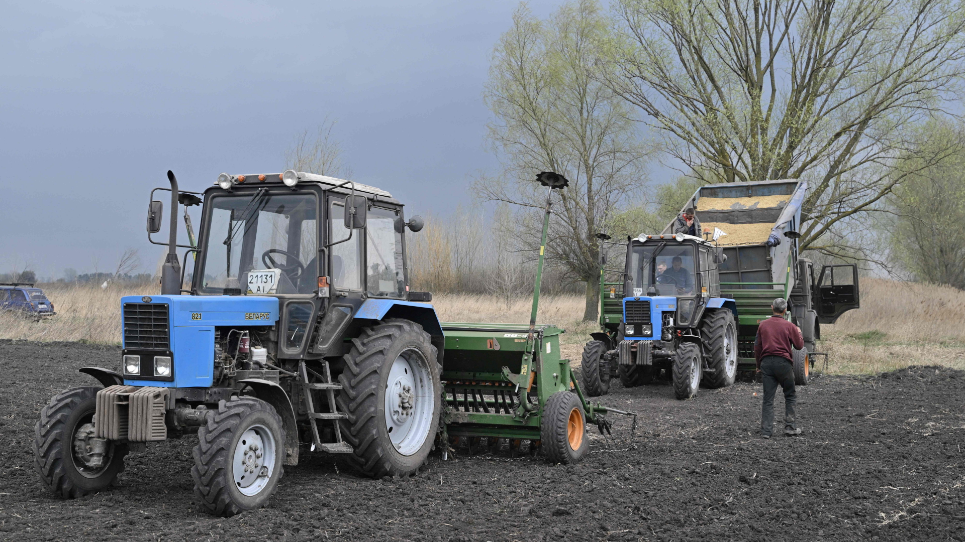 Ukrainische Bauern beladen eine Saatmaschine auf ihrem Feld östlich von Kiew. | AFP