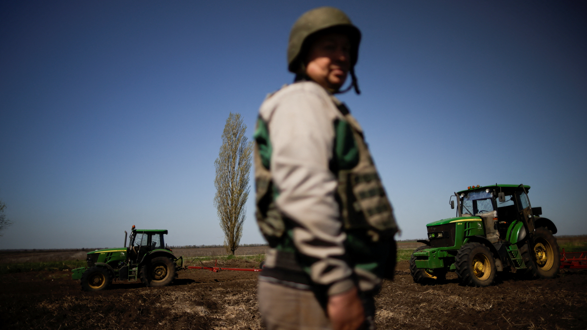 Ein ukrainischer Bauer trägt Helm und Schutzweste auf einem Feld bei Saporischschja (Ukraine) | REUTERS