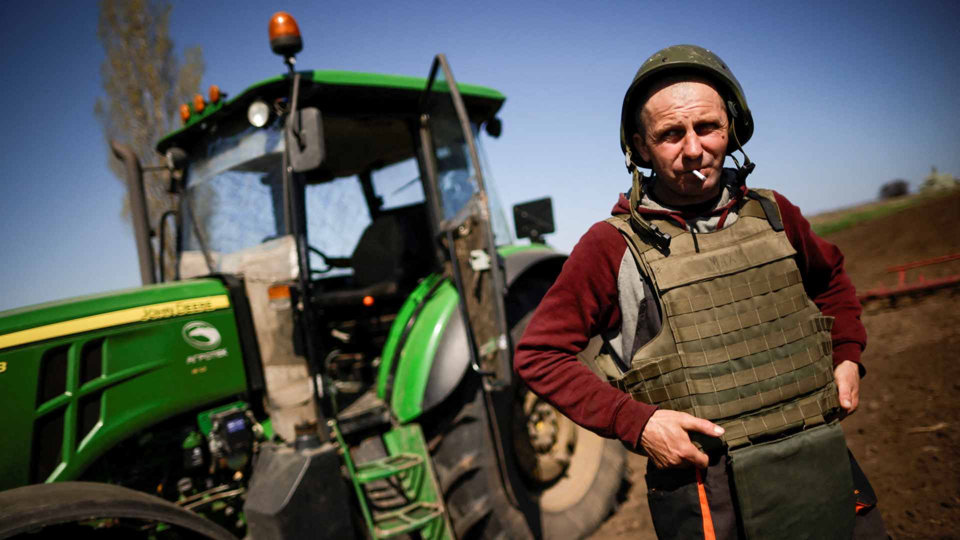 Ein Landwirt bestellt sein Feld bei Saporischschja (Ukraine) nur noch mit Helm und Schutzweste | REUTERS