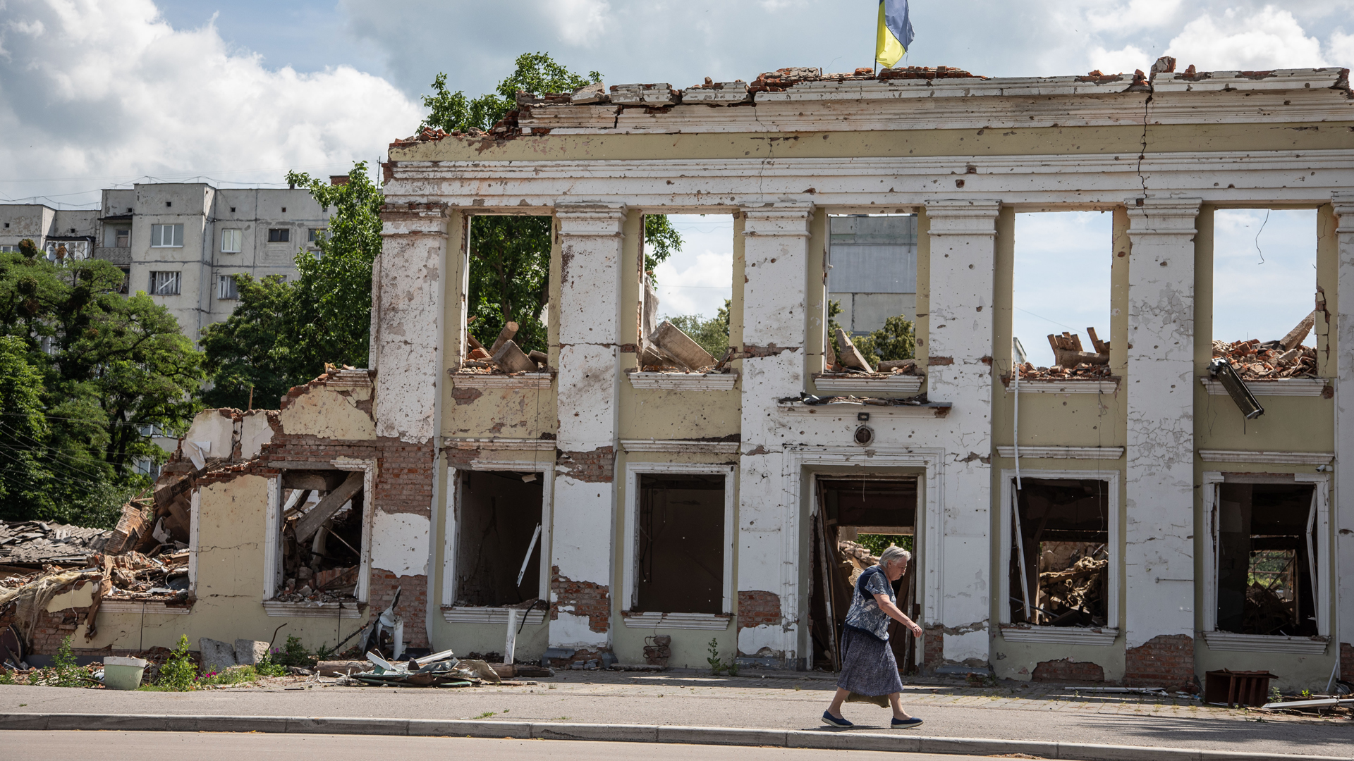 Eine Frau geht an einer Ruine des Stadtratsgebäudes von Ochtyrka in der Oblast Sumy vorbei. | picture alliance / ZUMAPRESS.com