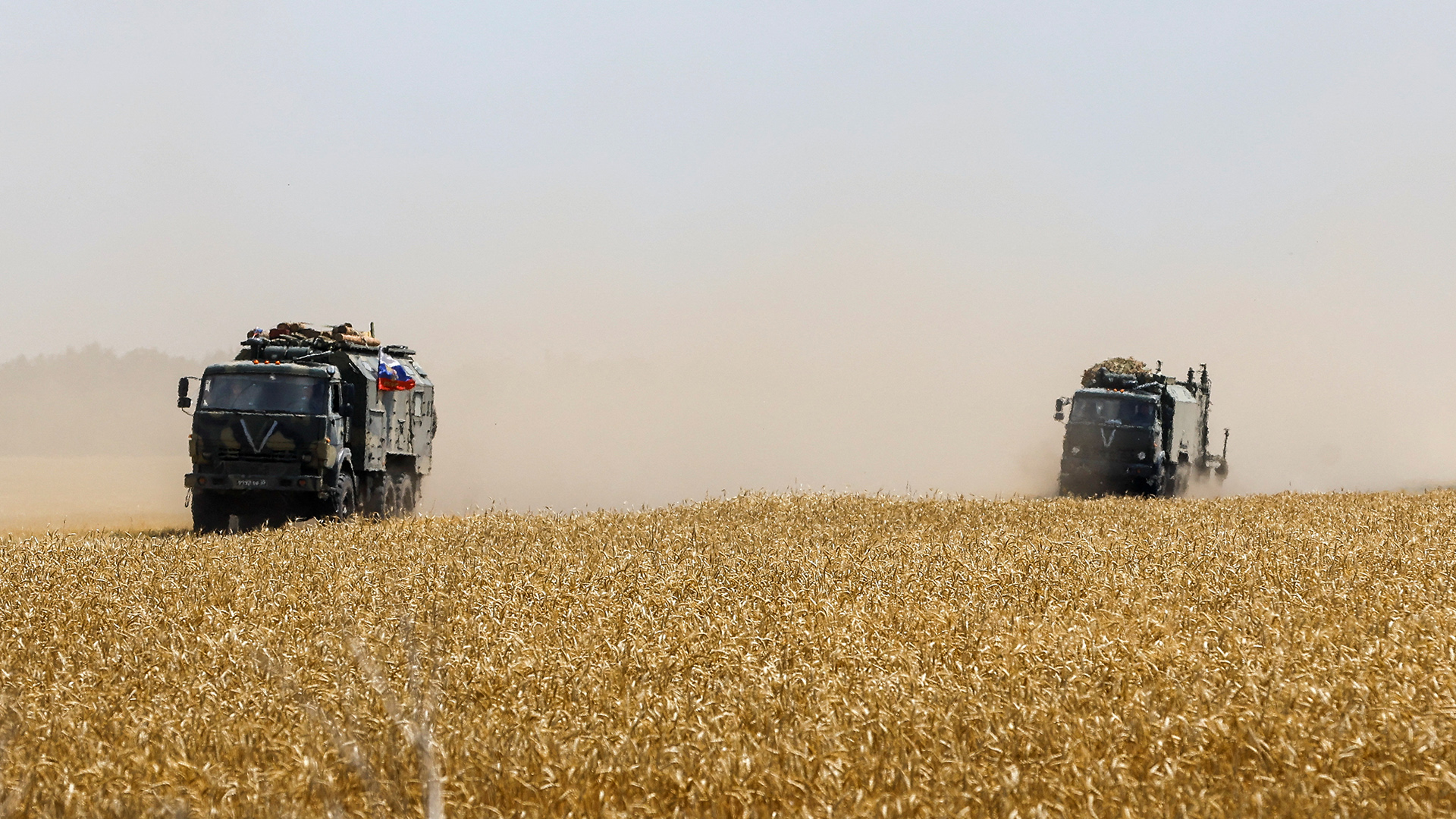 Lastwagen der russischen Armee fahren im Zuge des Ukraine-Russland-Konflikts nahe der Siedlung Oleniwka über ein Weizenfeld | REUTERS