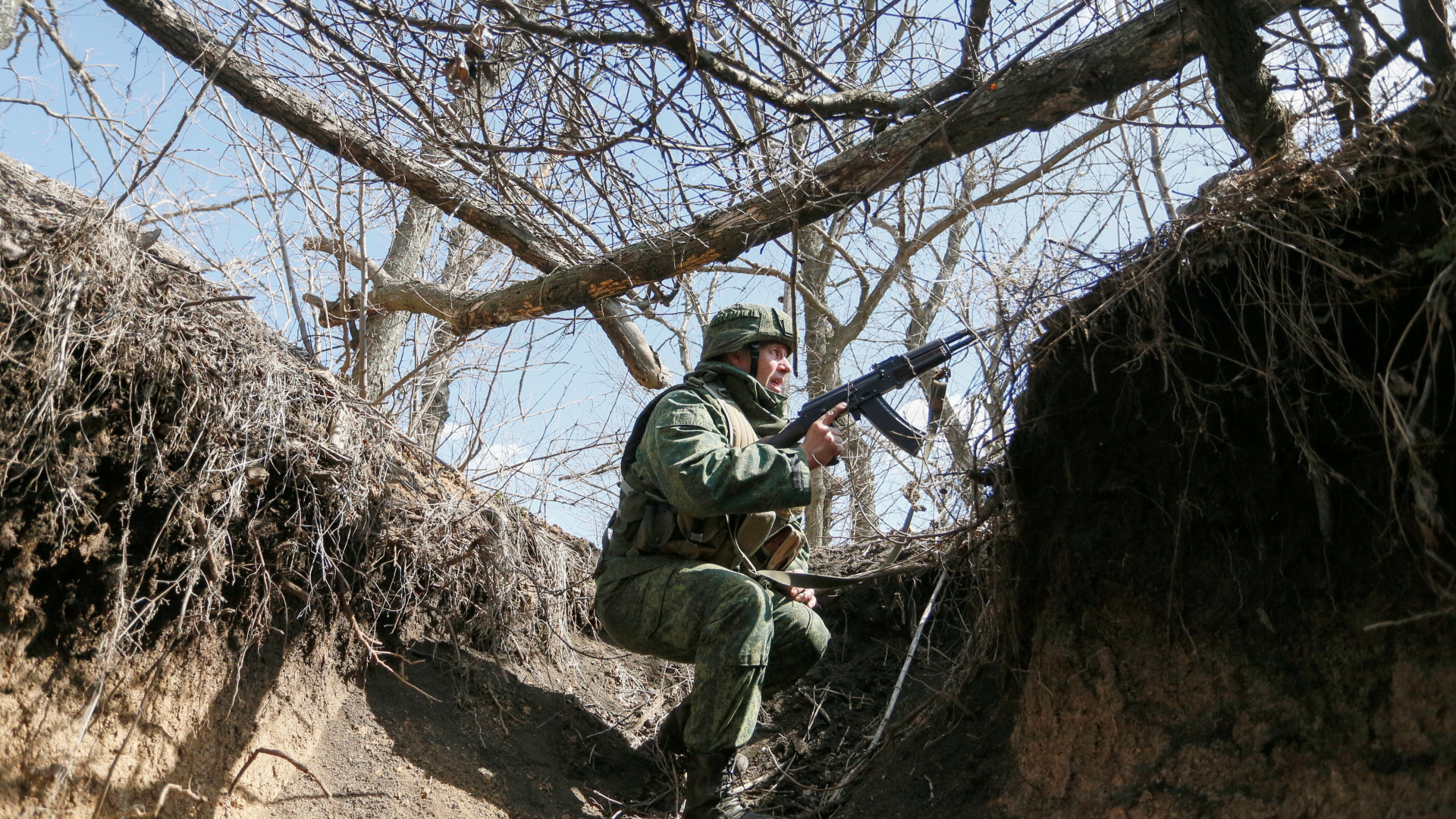 Ein Kämpfer der ostukrainischen Separatisten hockt in Kampfposition in einem Schützengraben bei Donezk | via REUTERS